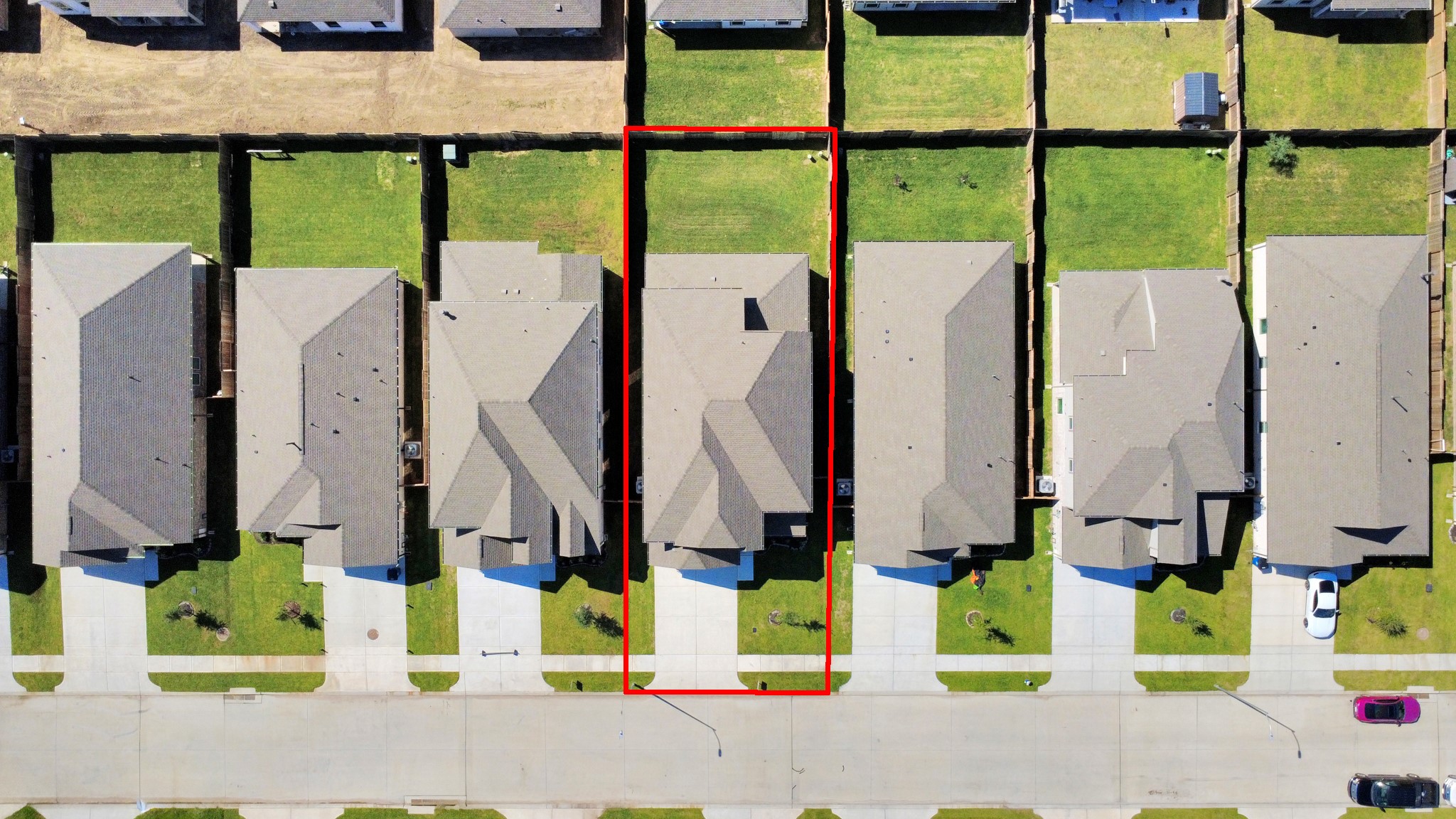 An aerial view of a spacious subdivision lot, highlighting a well-maintained yard and a fully fenced perimeter, offering both privacy and expansive outdoor space.