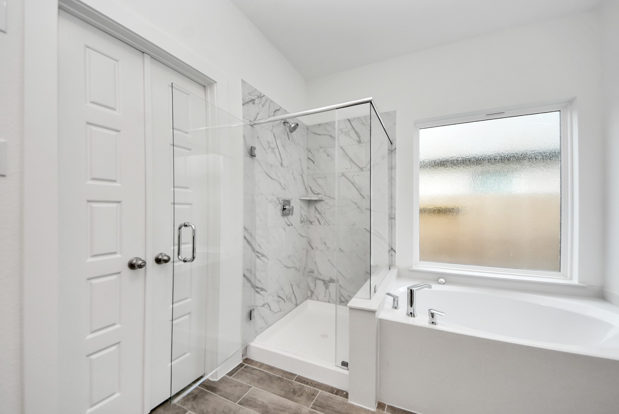 Indulge in a spa-like retreat within the confines of this primary bathroom. Delight in a spacious walk-in shower enveloped in stylish tile surround, unwind in a separate garden tub adorned with custom detailing.