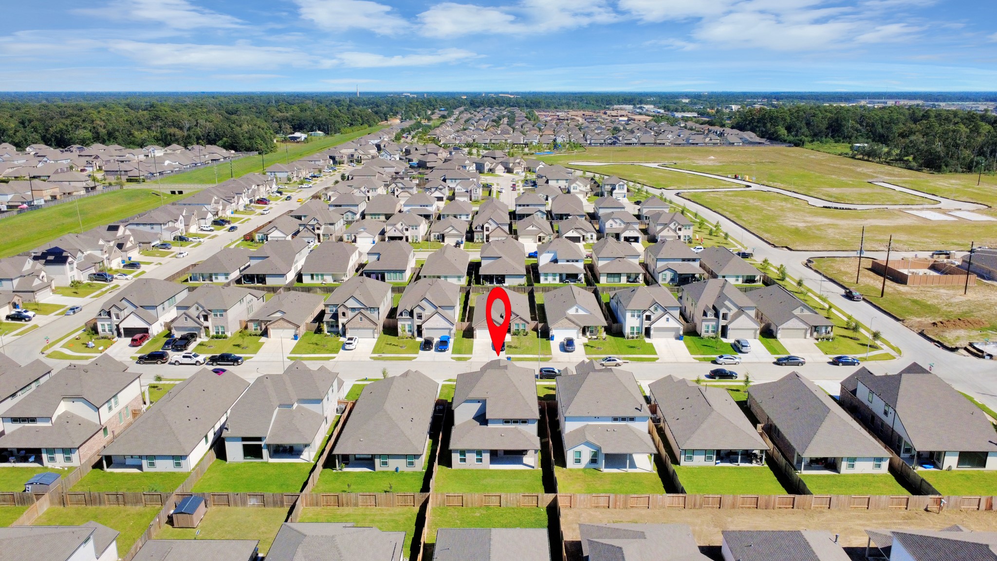 An aerial view of a spacious subdivision lot, highlighting a well-maintained yard and a fully fenced perimeter, offering both privacy and expansive outdoor space.