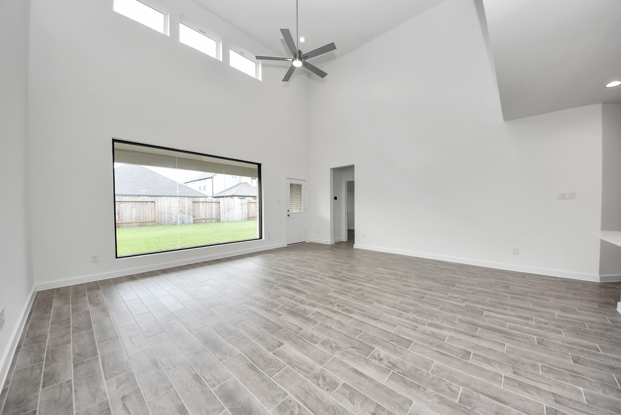Gather the family and guests together in your lovely living room! Featuring soaring high ceilings, recessed lighting, ceiling fan, custom paint, gorgeous floors, and large windows that provide plenty of natural lighting throughout the day.