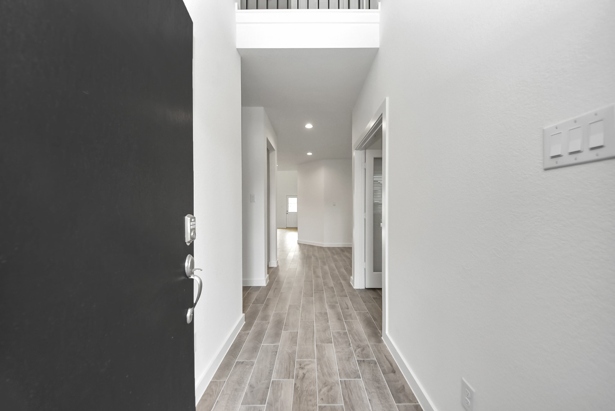 As you step into the threshold of this luxurious home, you'll soon be welcomed by an elegant glass door (to be installed). Inside, soaring ceilings amplify the spaciousness, while the refined wood-look tile flooring and oversized baseboards exude sophistication and charm.