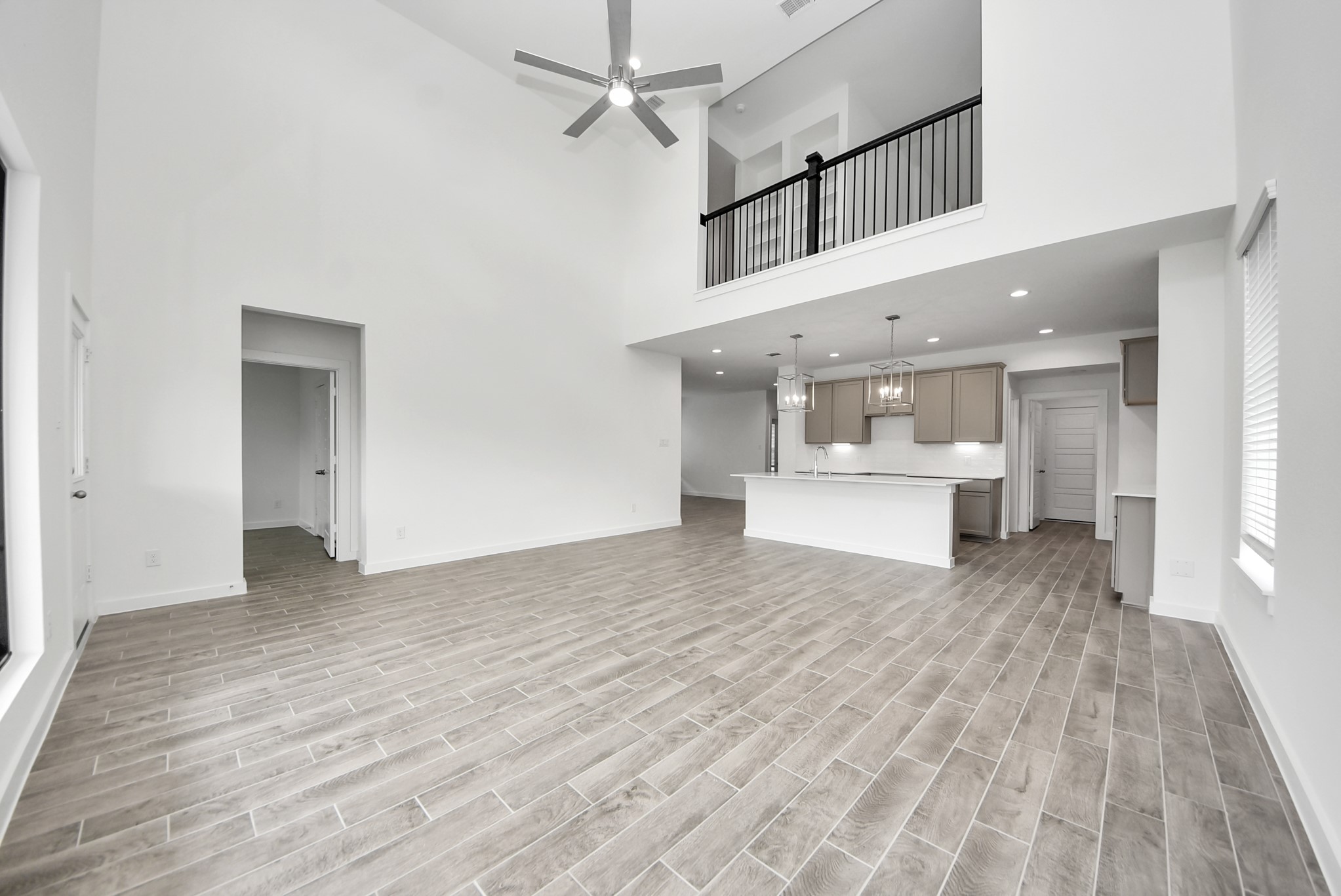Family room flooded with natural light through the expansive windows.  The premium tile flooring adds a touch of luxury to the space, creating the perfect setting for relaxing moments and cherished gatherings with loved ones