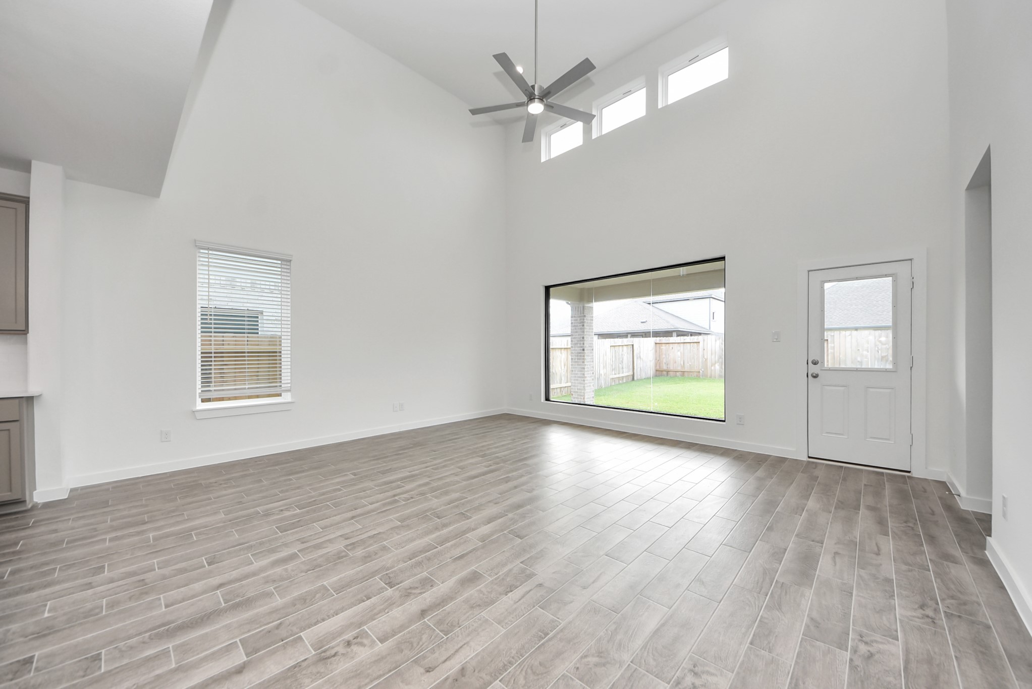 Welcome family and guests to your charming living room! With its high ceilings, recessed lighting, ceiling fan, custom paint, beautiful flooring, and large windows that let in abundant natural light, this room is perfect for gatherings.