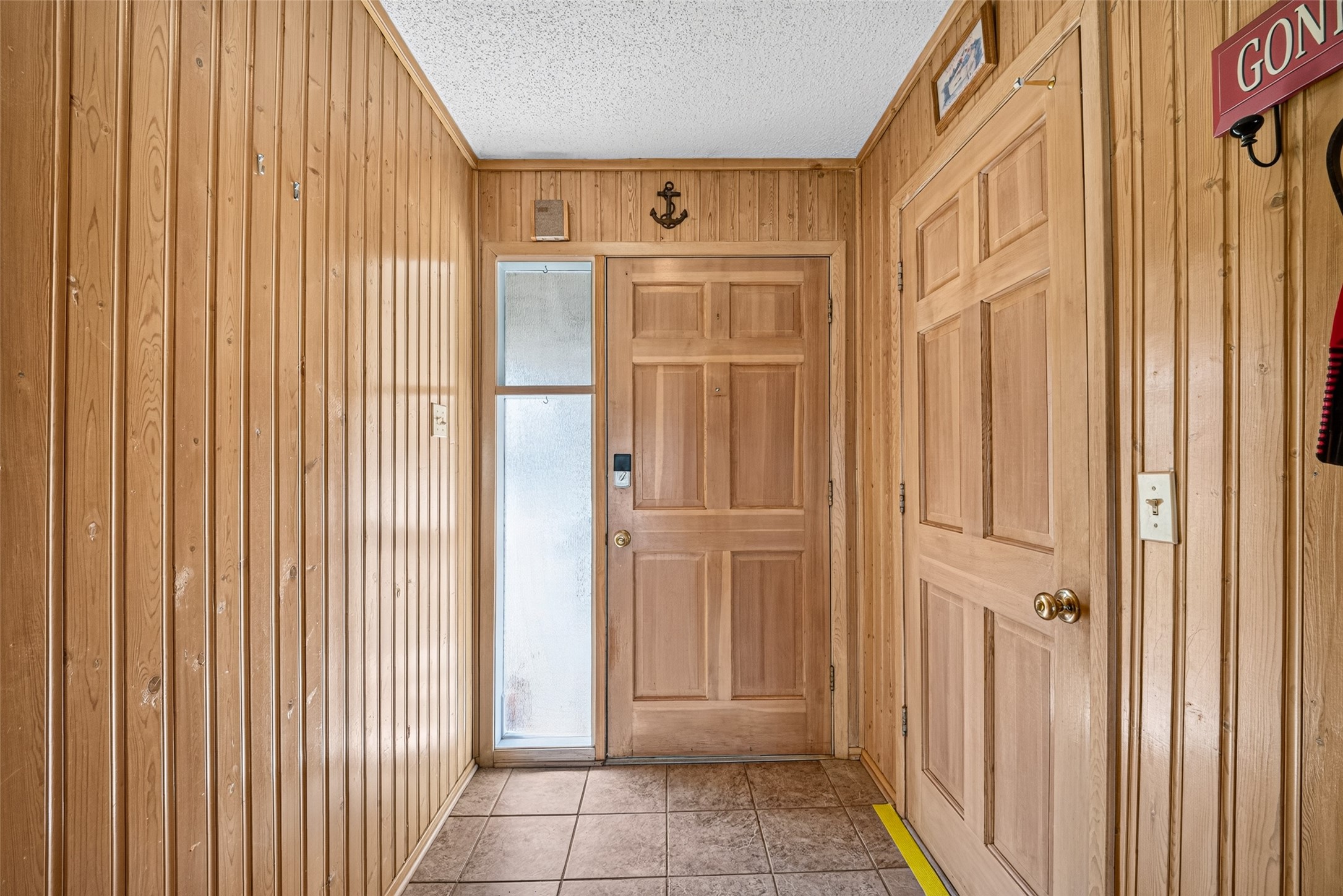 Interior view with wood panel throughout and tile flooring