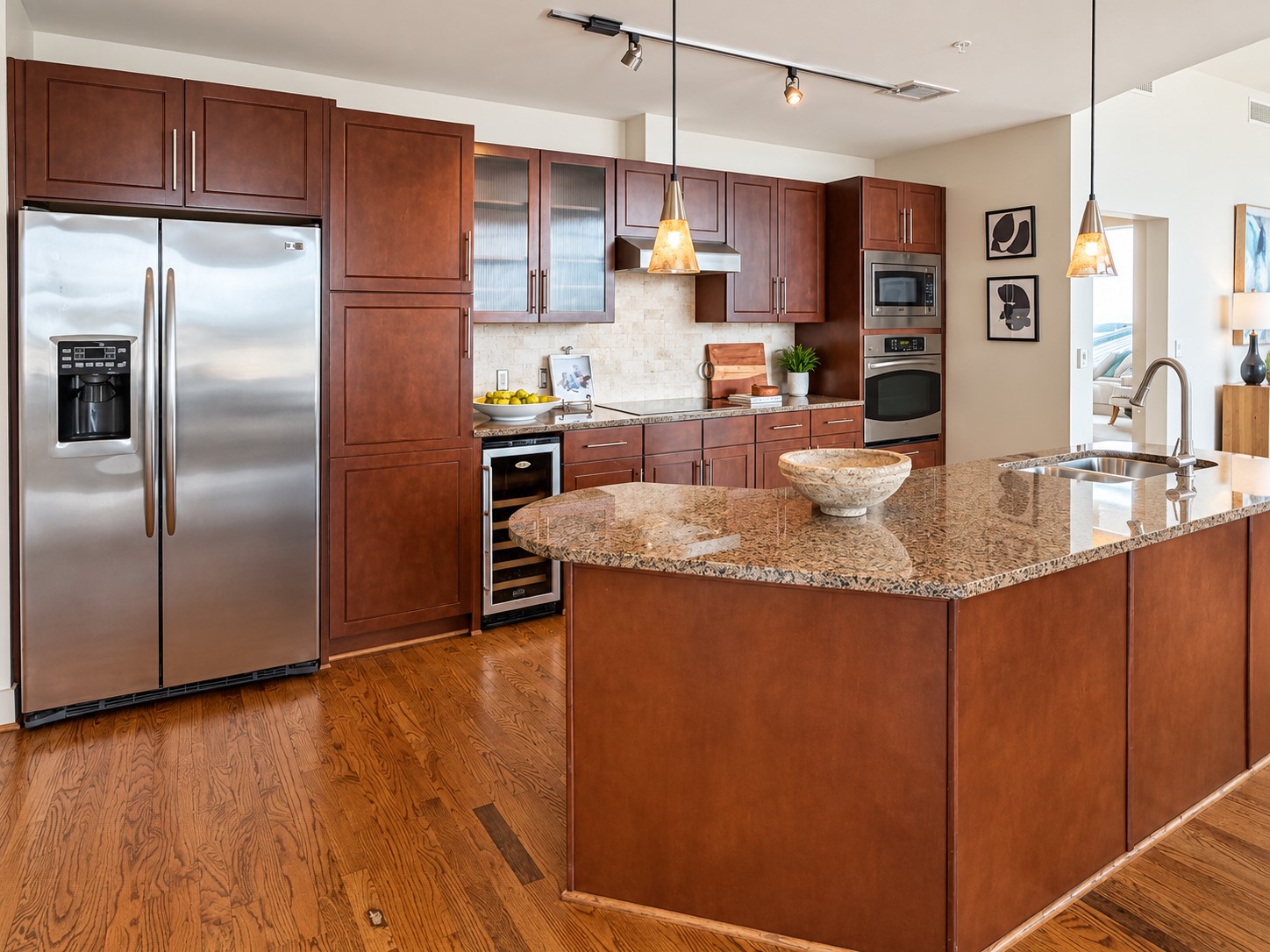 The kitchen is truly made for gathering, with an expansive granite island creating a natural centerpiece for morning coffee, casual dinners and evenings spent entertaining. Rich cabinetry, stainless-steel appliances and warm hardwood floors give the space a timeless, residential feel.