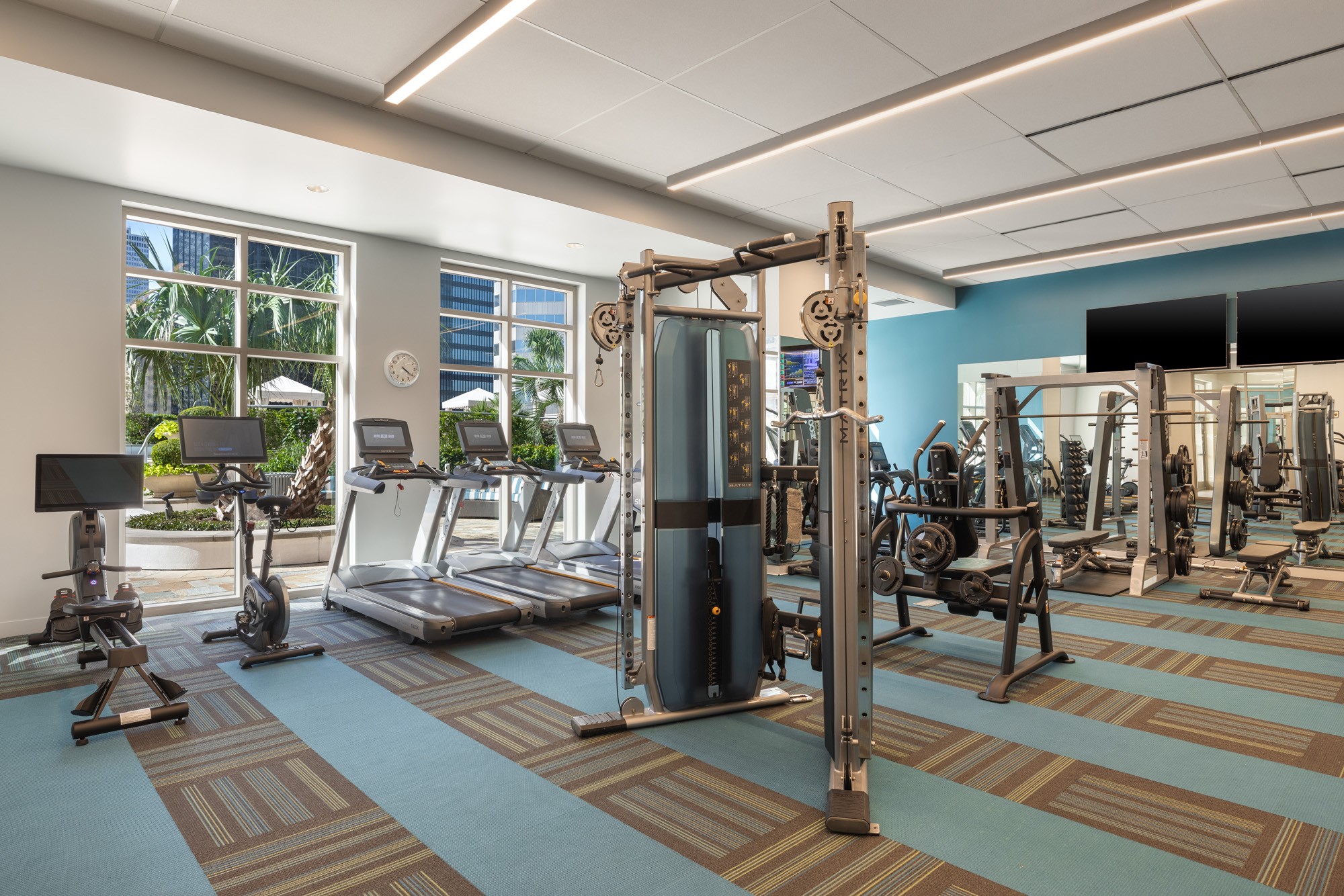 A spacious, light-filled state-of-the-art fitness center equipped with premium cardio machines, free weights, cable systems, and strength-training equipment. Expansive windows overlooking the resort-style pool create an energizing atmosphere, making it easy to stay active without leaving home.