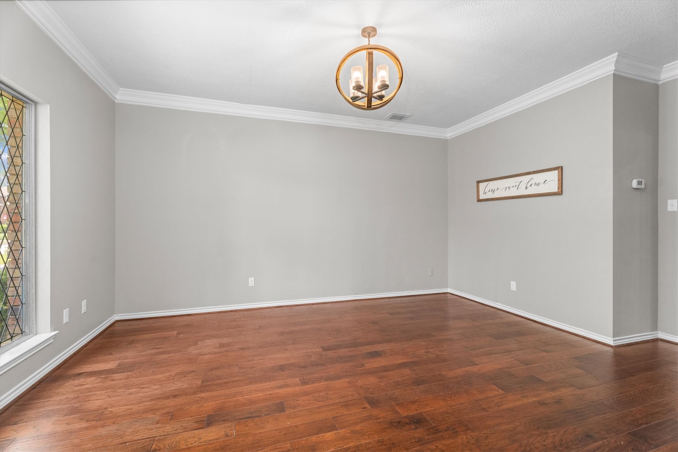 Mirroring the formal dining room across the entry way, this room also features leaded glass windows, crown molding, and a stylish chandelier.