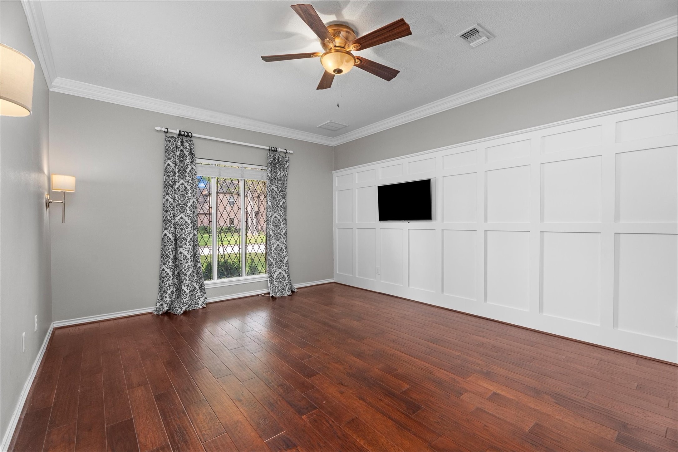 The primary suite features leaded glass windows, crown molding, and a classic accent wall, with room for all your furniture.