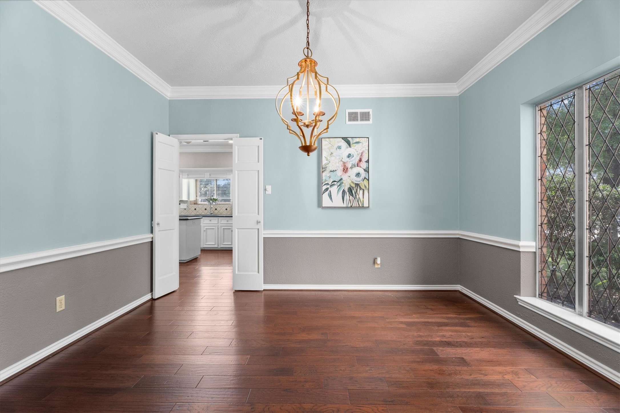 Classic Champion Forest charm abounds in this formal dining room - crown molding and decorative trim, leaded glass windows, and a stylish chandelier.
