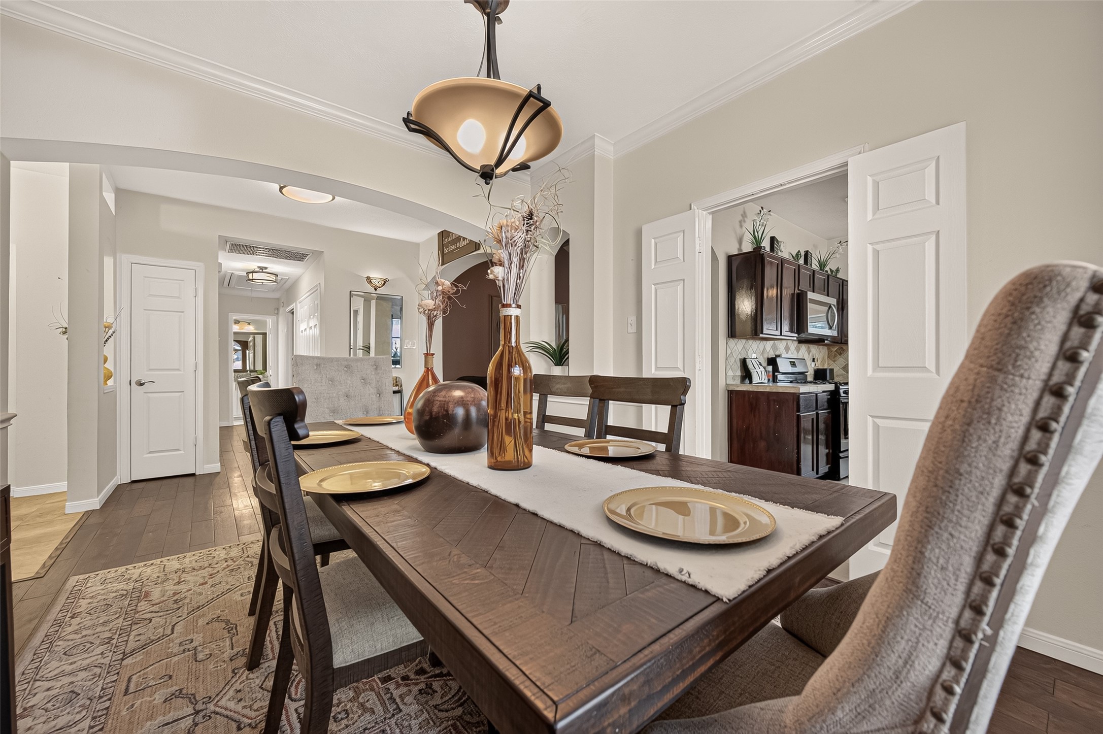 Elegant dining room featuring stylish lighting, and easy access to a modern kitchen, perfect for entertaining.