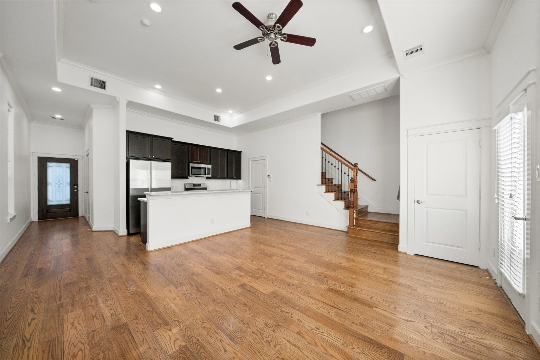 Another view of your living room, with access to your outdoor space through the door on the right. At the bottom of the stairs is one of your conveniently placed half baths.