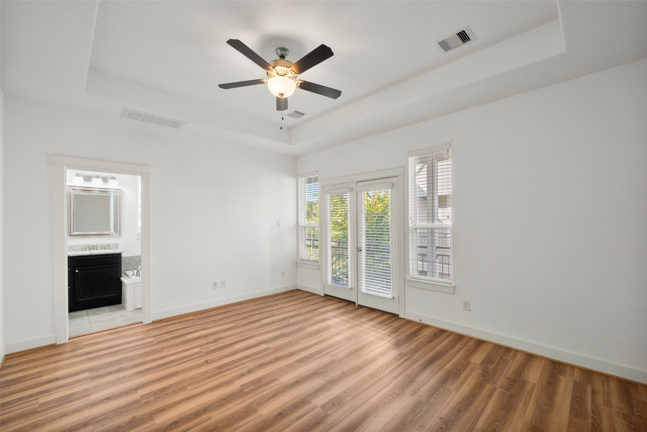 Step into your primary suite located on the second floor. This room features new luxury vinyl plank flooring, a tray ceiling, ensuite bath, as well as a large walk-in closet.