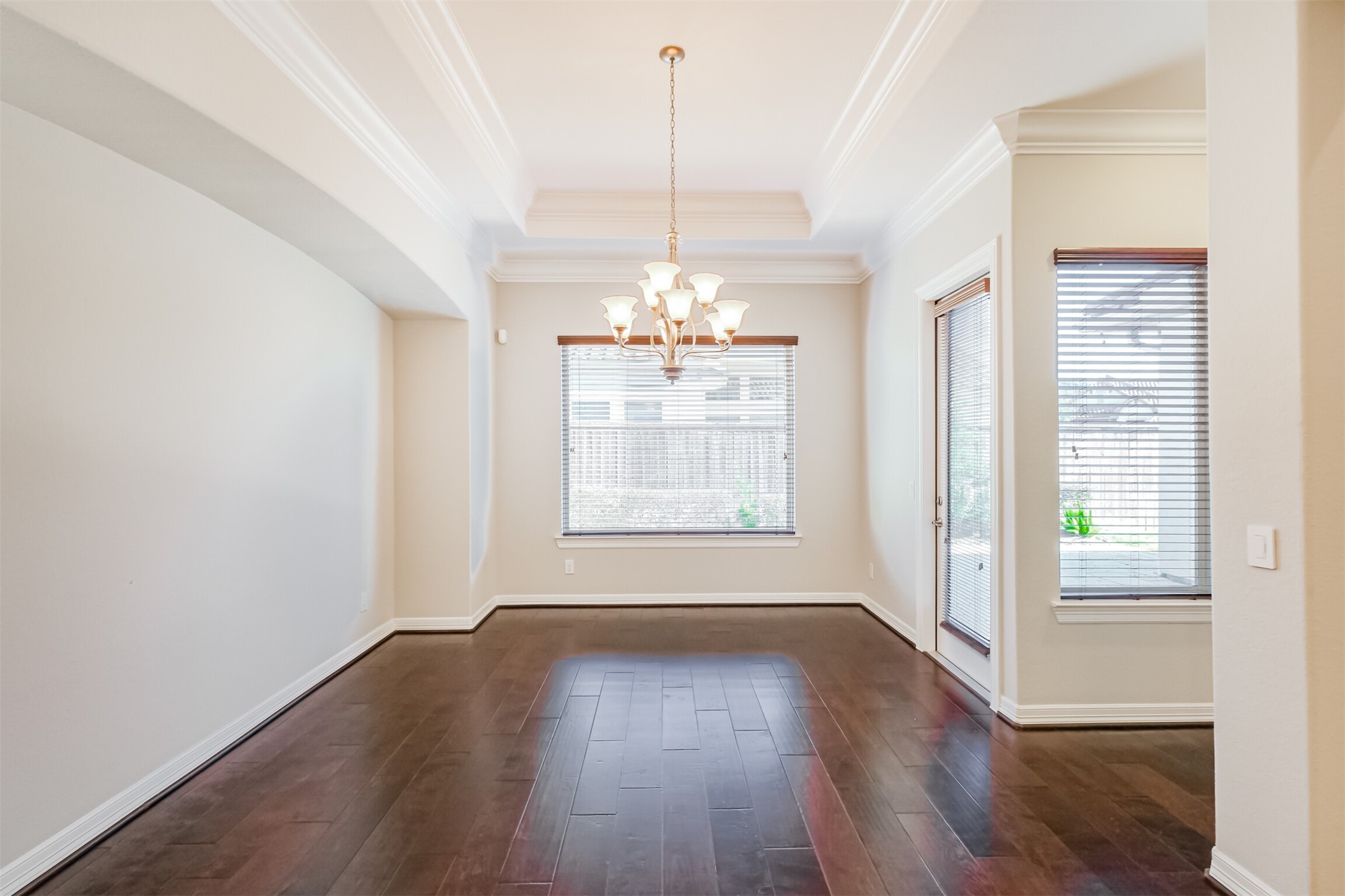 Elegant tray ceiling and architectural niche bring refined flair to this generous dining area.