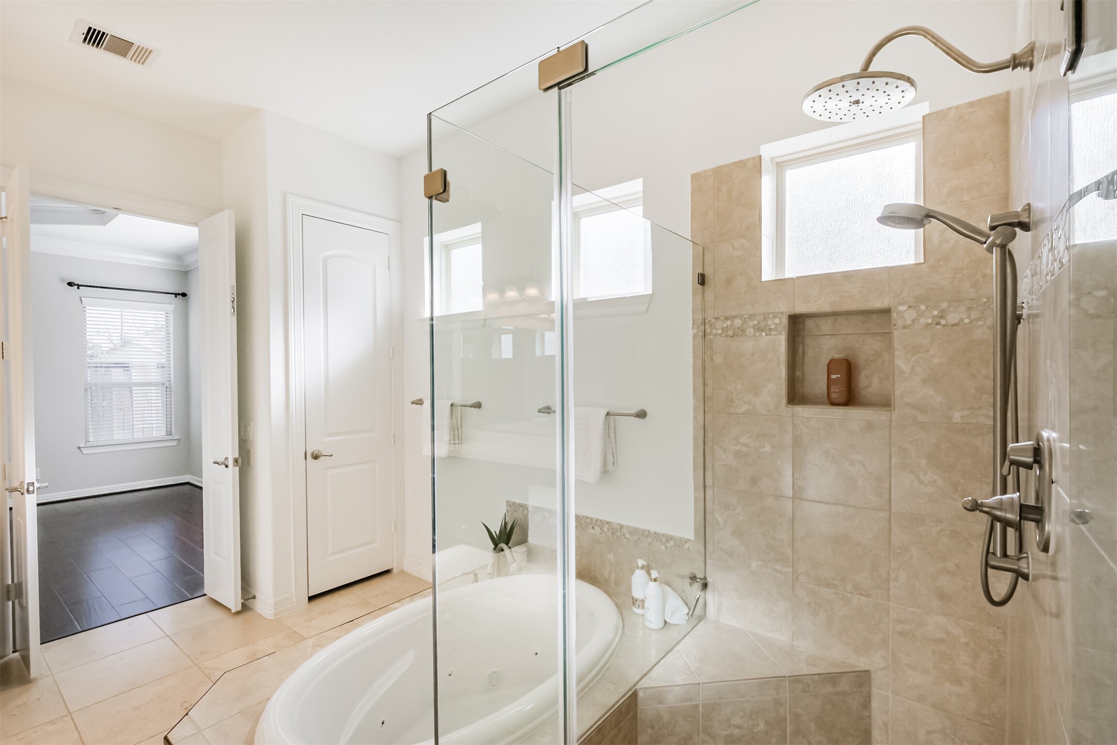 Spacious frameless shower with dual heads and separate controls.