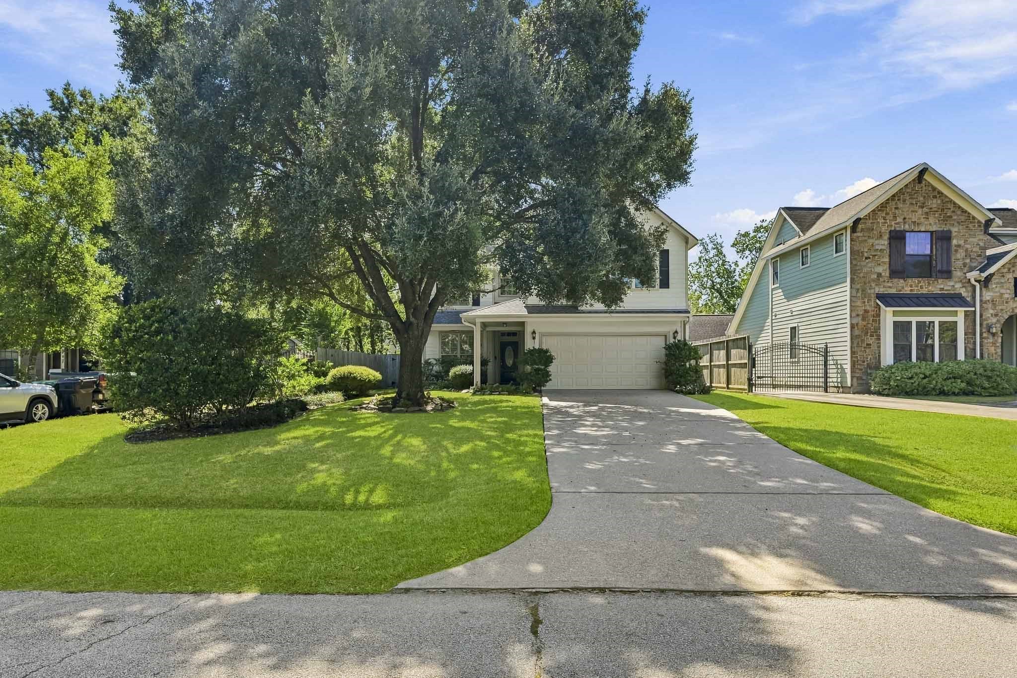 Attractive exterior with mature trees, manicured landscaping, and a charming covered entry.