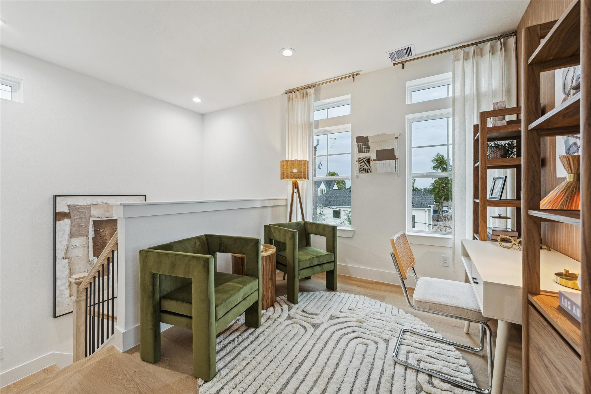 Bright and inviting loft space featuring modern decor, large windows for natural light, and a cozy seating area ideal for relaxation or work.