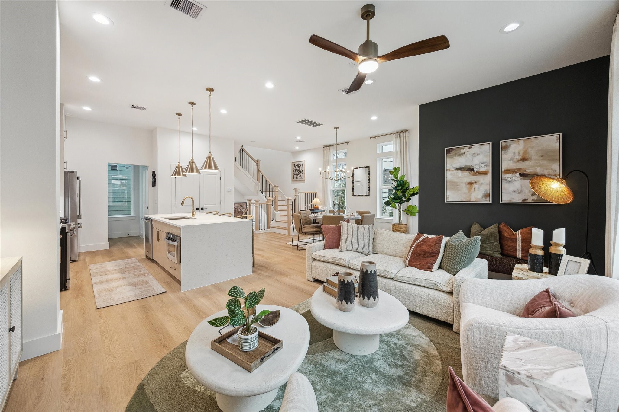 Spacious open-concept living area with modern finishes, featuring a sleek kitchen island, cozy seating, and elegant lighting, perfect for entertaining.
