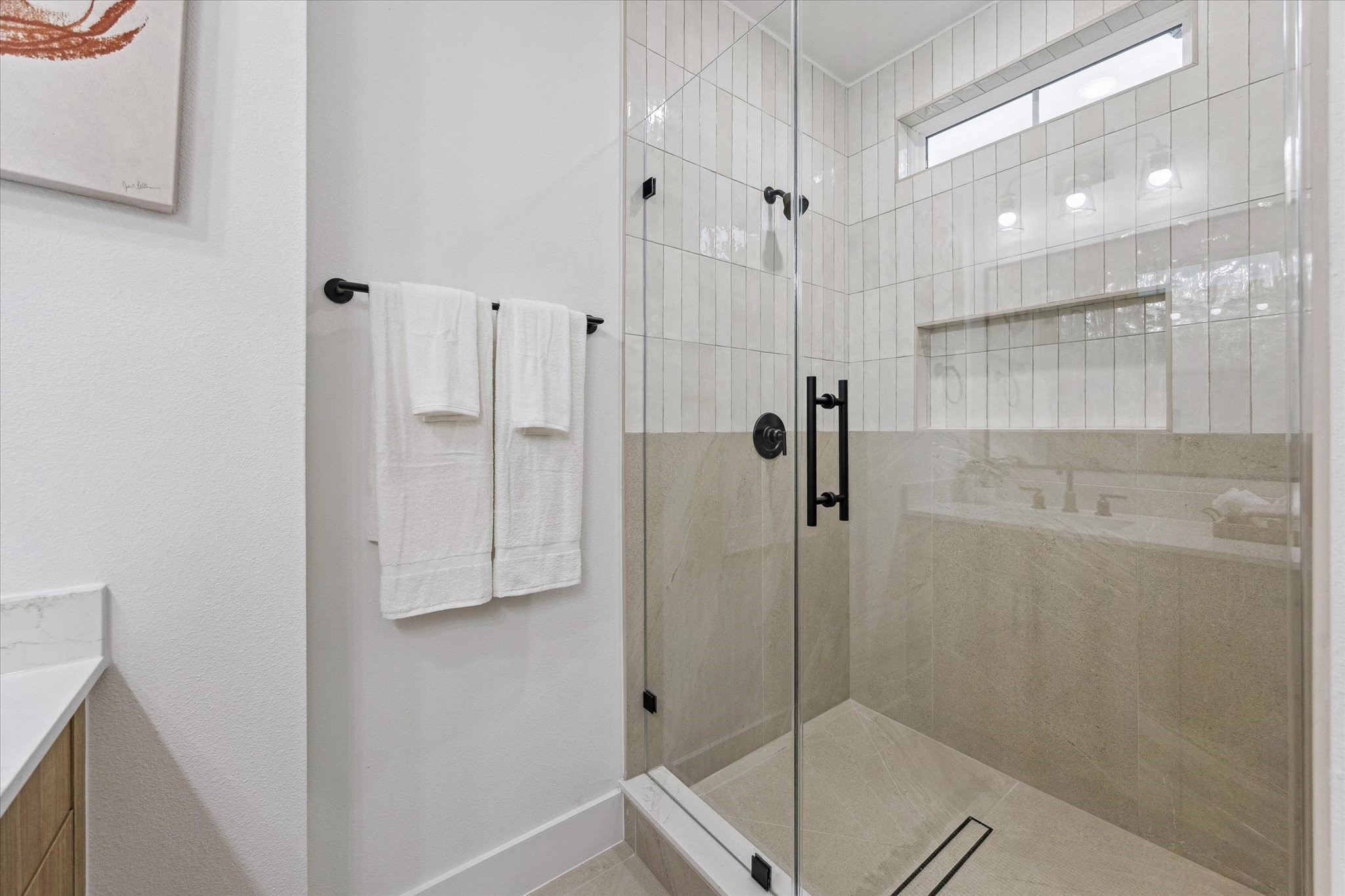 Elegant bathroom featuring a spacious glass-enclosed shower with modern fixtures and stylish tile design.