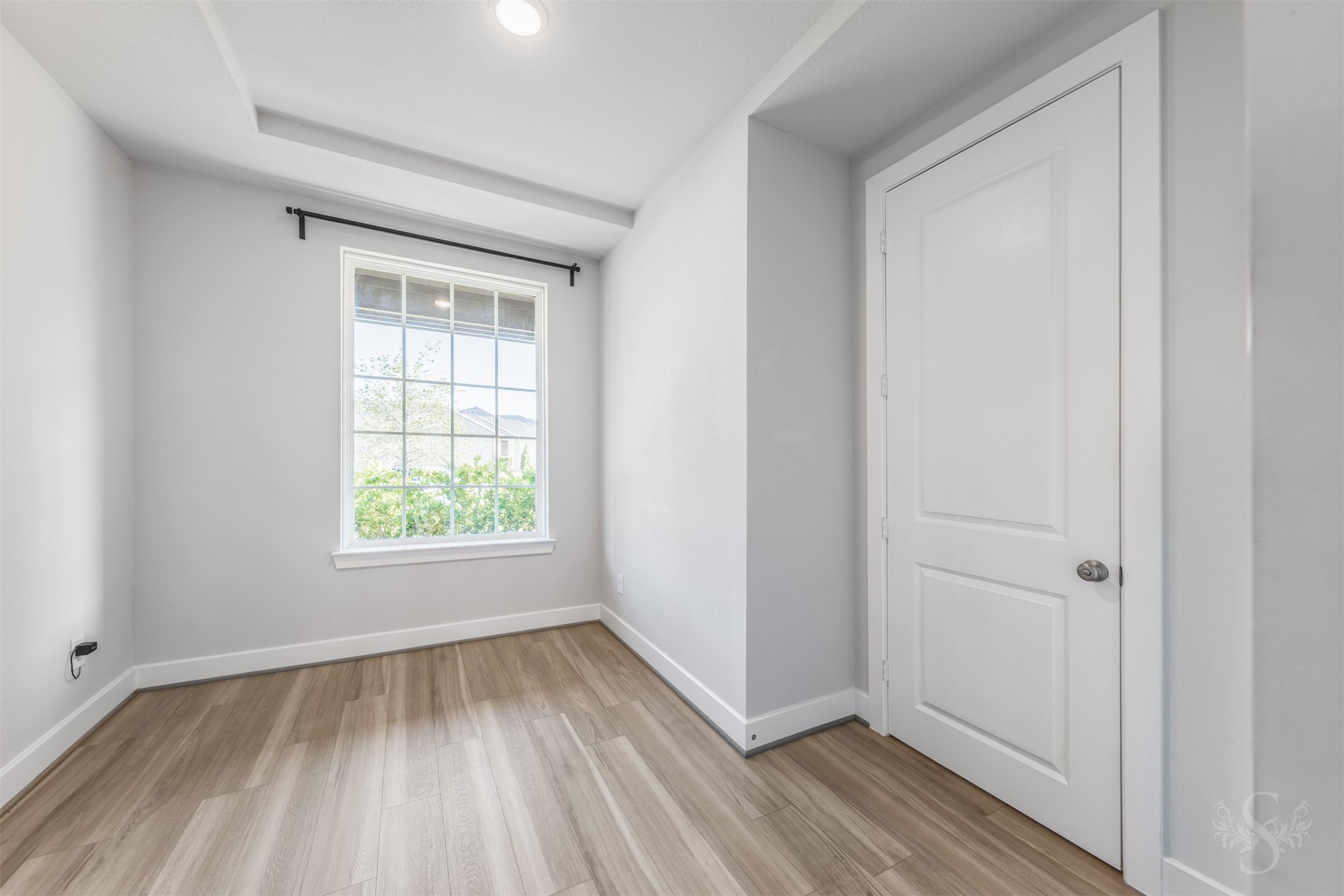 A tray ceiling and gorgeous flooring add stylish detail to the formal dining room. A large window brightens this inviting space, ready for family dinners and entertaining friends.