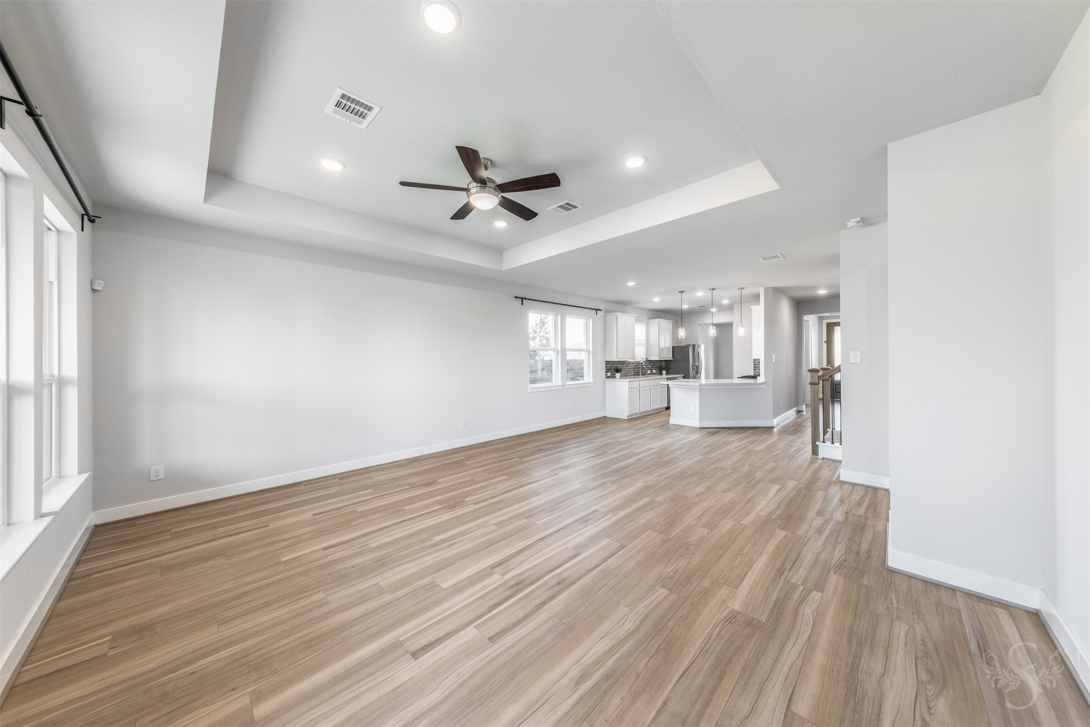 A striking tray ceiling and gorgeous wood flooring showcase the spacious family room, with plenty of space for comfortable seating. The open concept floor plan brings the family room, breakfast room and stylish kitchen together for everyday living and entertaining.