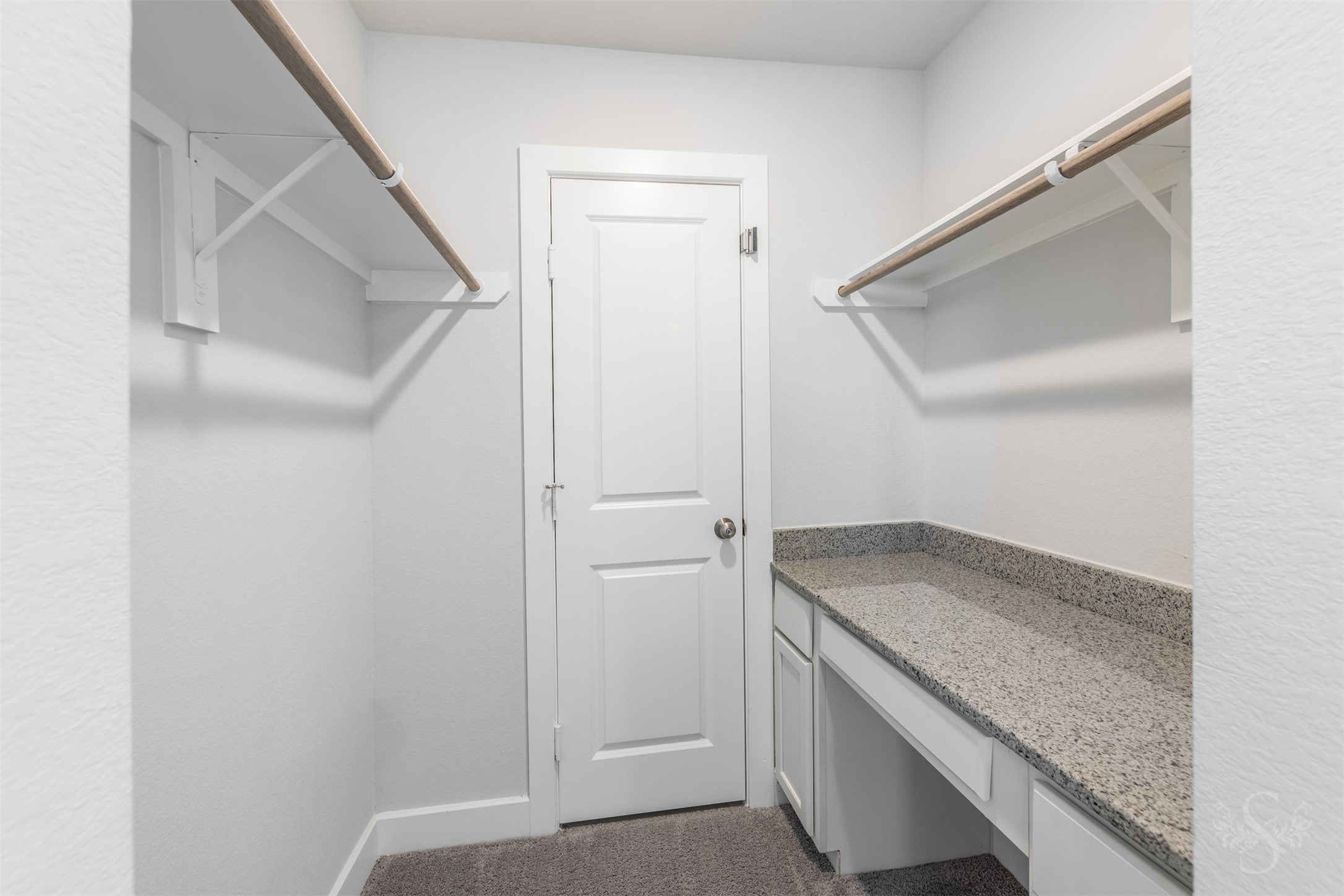 A tucked-away planning center features a built-in desk with a granite counter, drawers and cabinetry. This convenient space is ideal for homework, managing household paperwork or keeping school supplies organized.