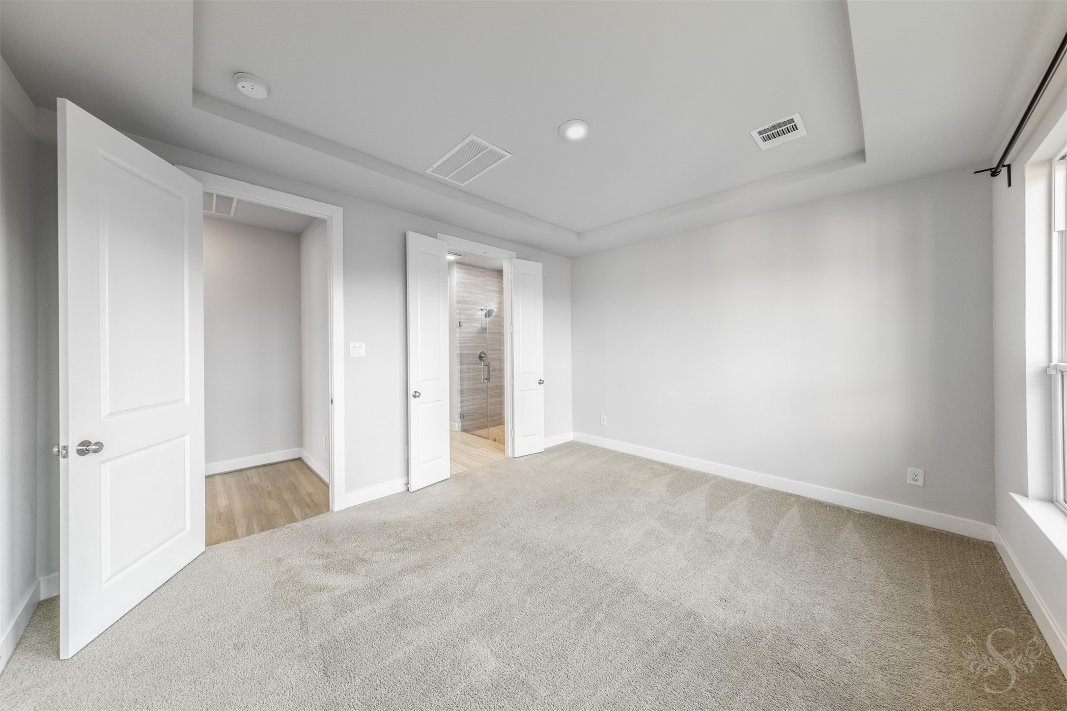 Generous wall space provides flexibility for arranging your bedroom furniture beneath the beautiful tray ceiling. Double doors lead into the private primary bath, completing this comfortable retreat.