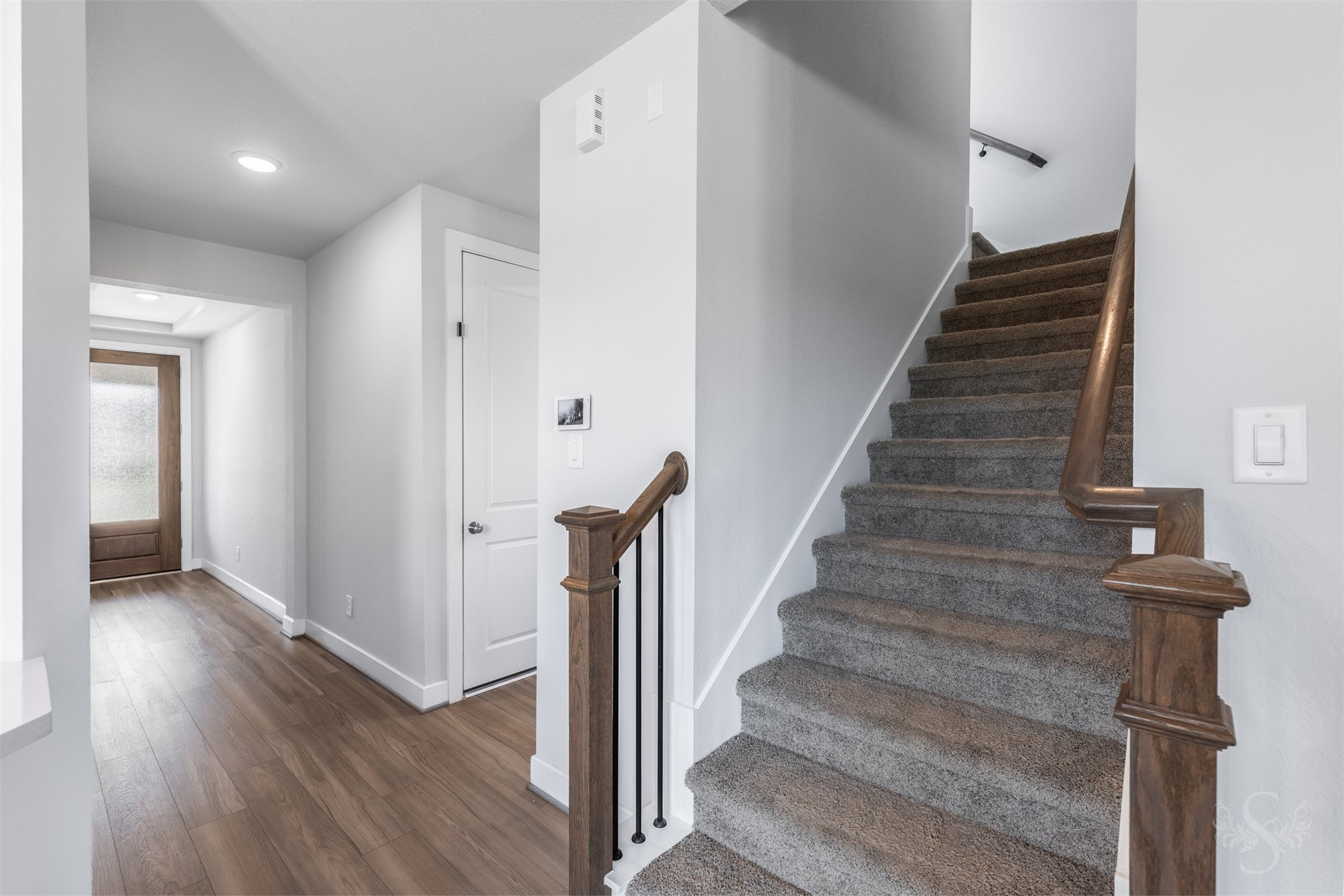The staircase features rich wood handrails and iron balusters. Upstairs, three bedrooms and a spacious game room provide plenty of space for family living.