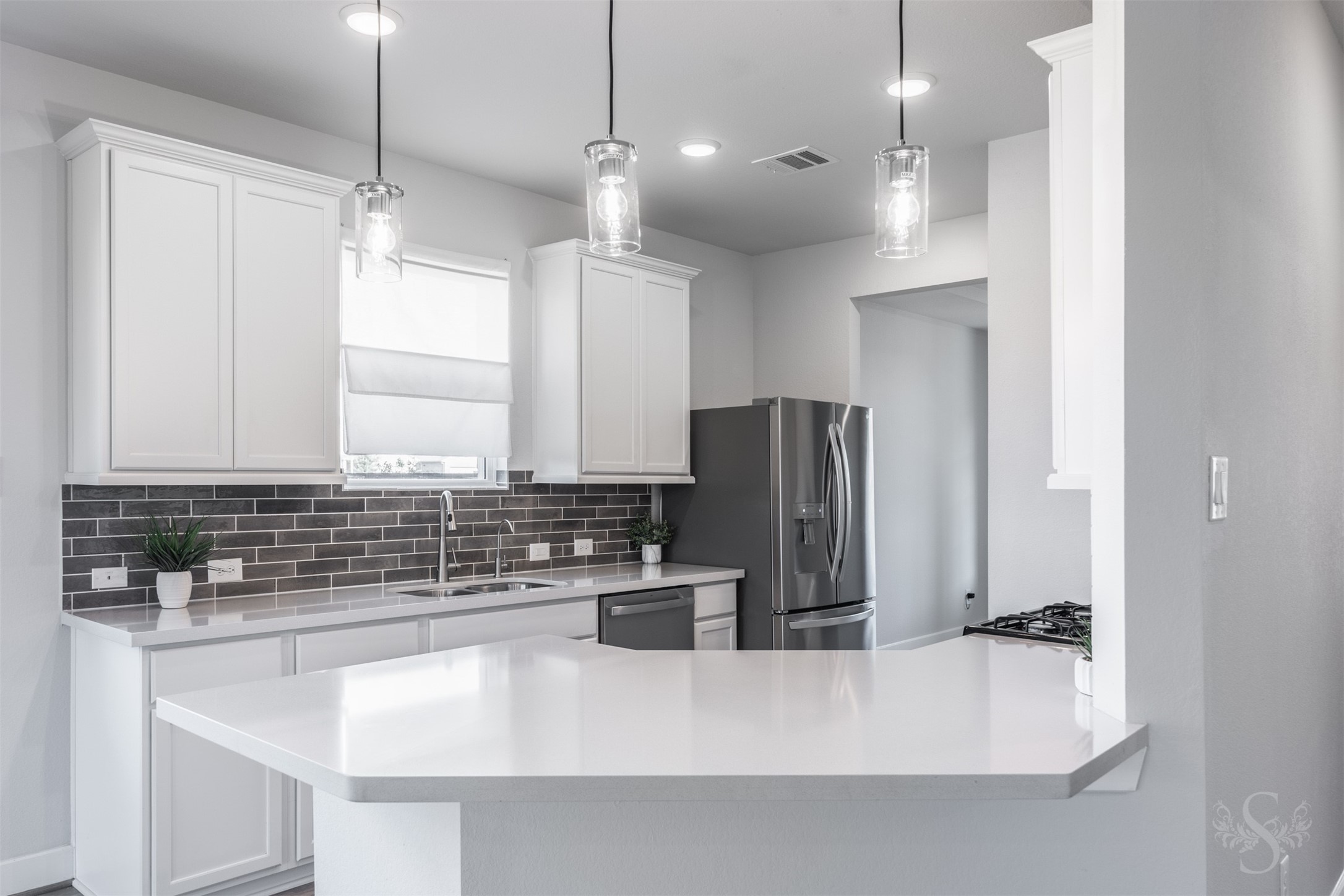A tray ceiling and gorgeous flooring add stylish detail to the formal dining room. A large window brightens this inviting space, ready for family dinners and entertaining friends.