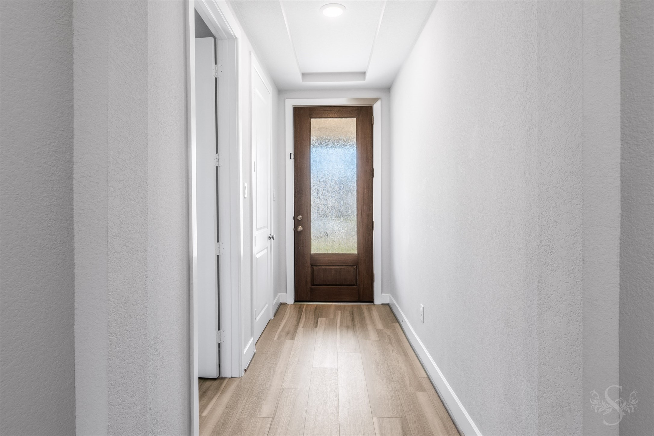 A tray ceiling and beautiful wood flooring set an elegant tone in the welcoming entry. Soft neutral walls and tall doorways create a bright, airy passage into the heart of the home.