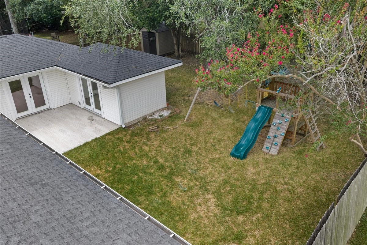 Expansive backyard with a charming play set and a spacious patio, perfect for family gatherings and outdoor enjoyment.