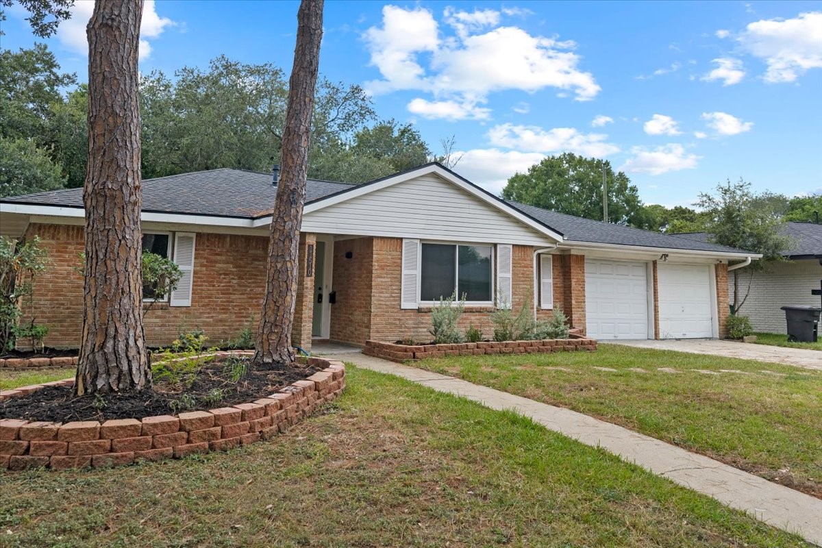 Charming brick home with a welcoming porch, two-car garage, and beautifully landscaped front yard. Charming brick home with a welcoming porch, two-car garage, and beautifully landscaped front yard.