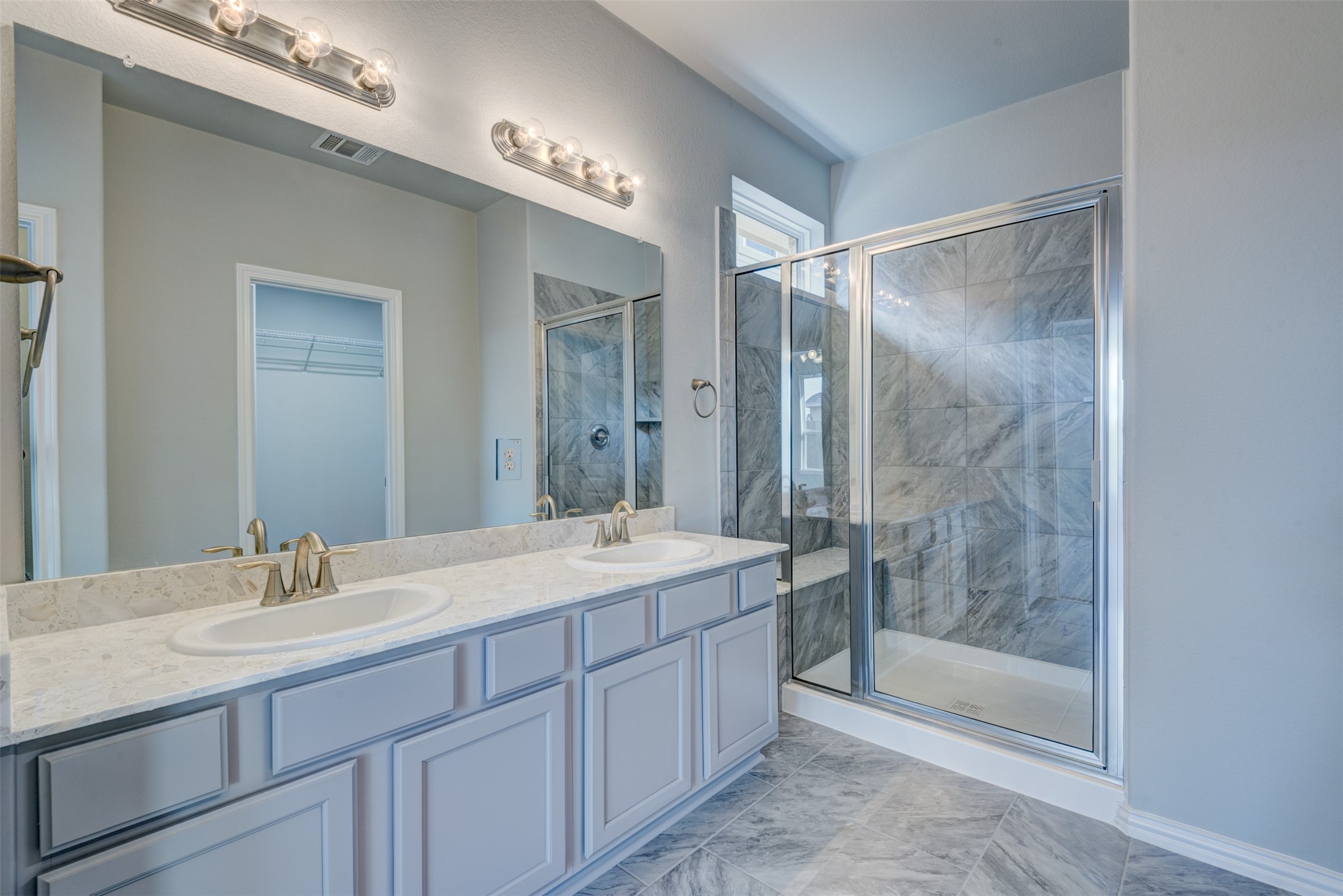 Primary suite offers 2 sinks at the vanity and over-sized walk-in shower with seat