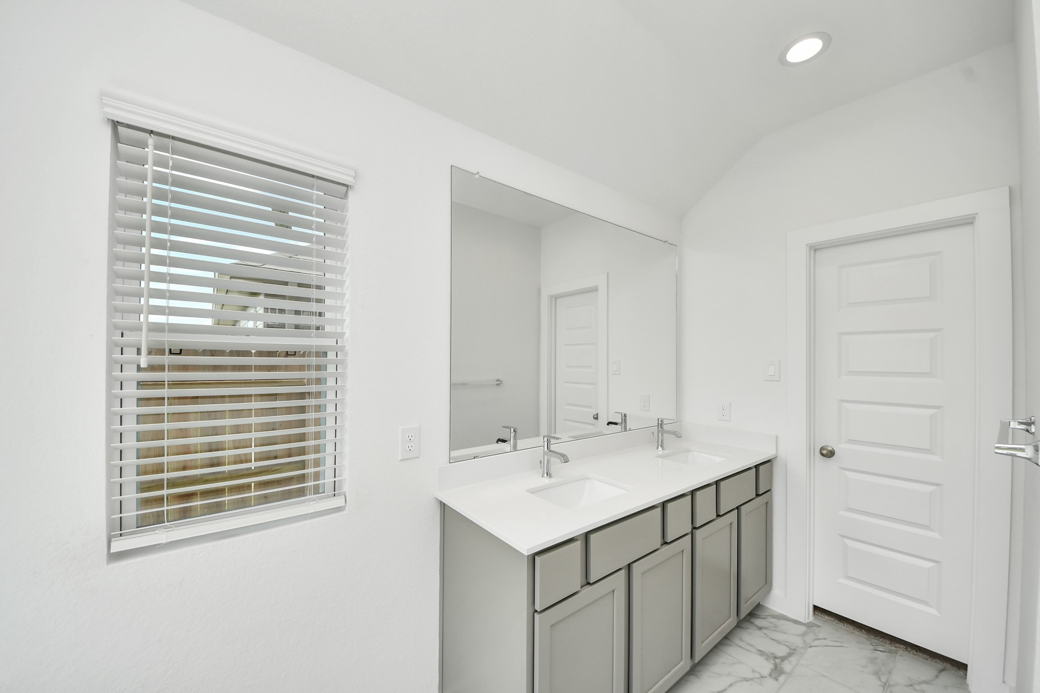 Elevate your daily routine at the elegant vanity, now equipped with double sinks, light countertops, modern hardware, and beautiful recessed lights. Sample photo of completed home with similar floor plan. Actual colors and selections may vary.