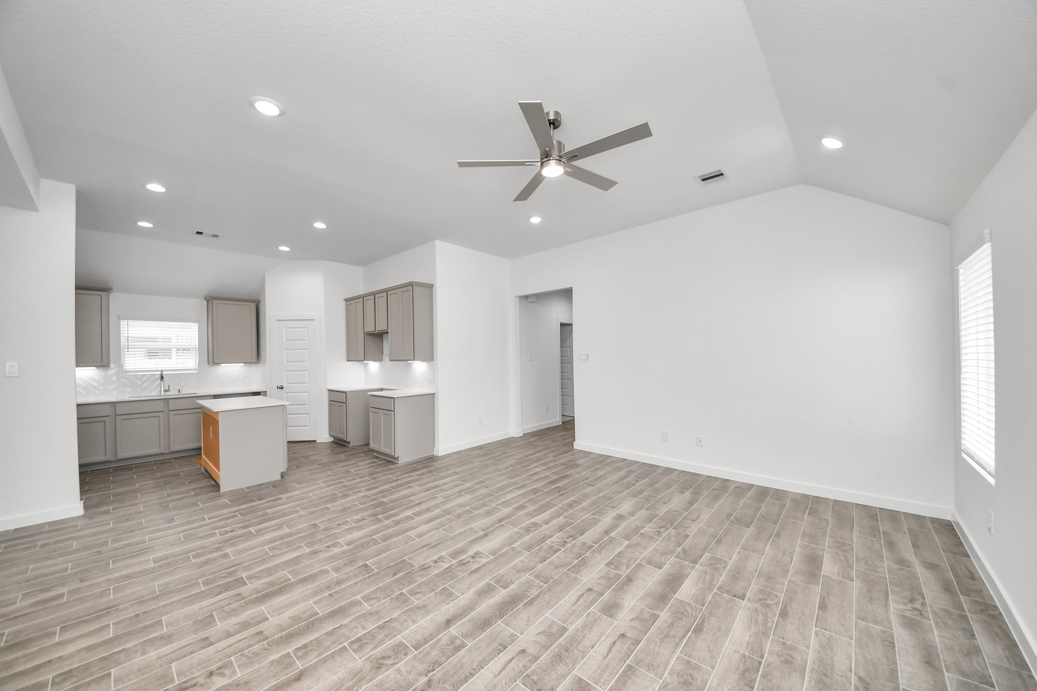 Gather the family and guests together in your lovely living room! Featuring soaring high ceilings, recessed lighting, ceiling fan, custom paint, gorgeous floors, and large windows that provide plenty of natural lighting throughout the day. Sample photo of completed home with similar floor plan. Actual colors and selections may vary.