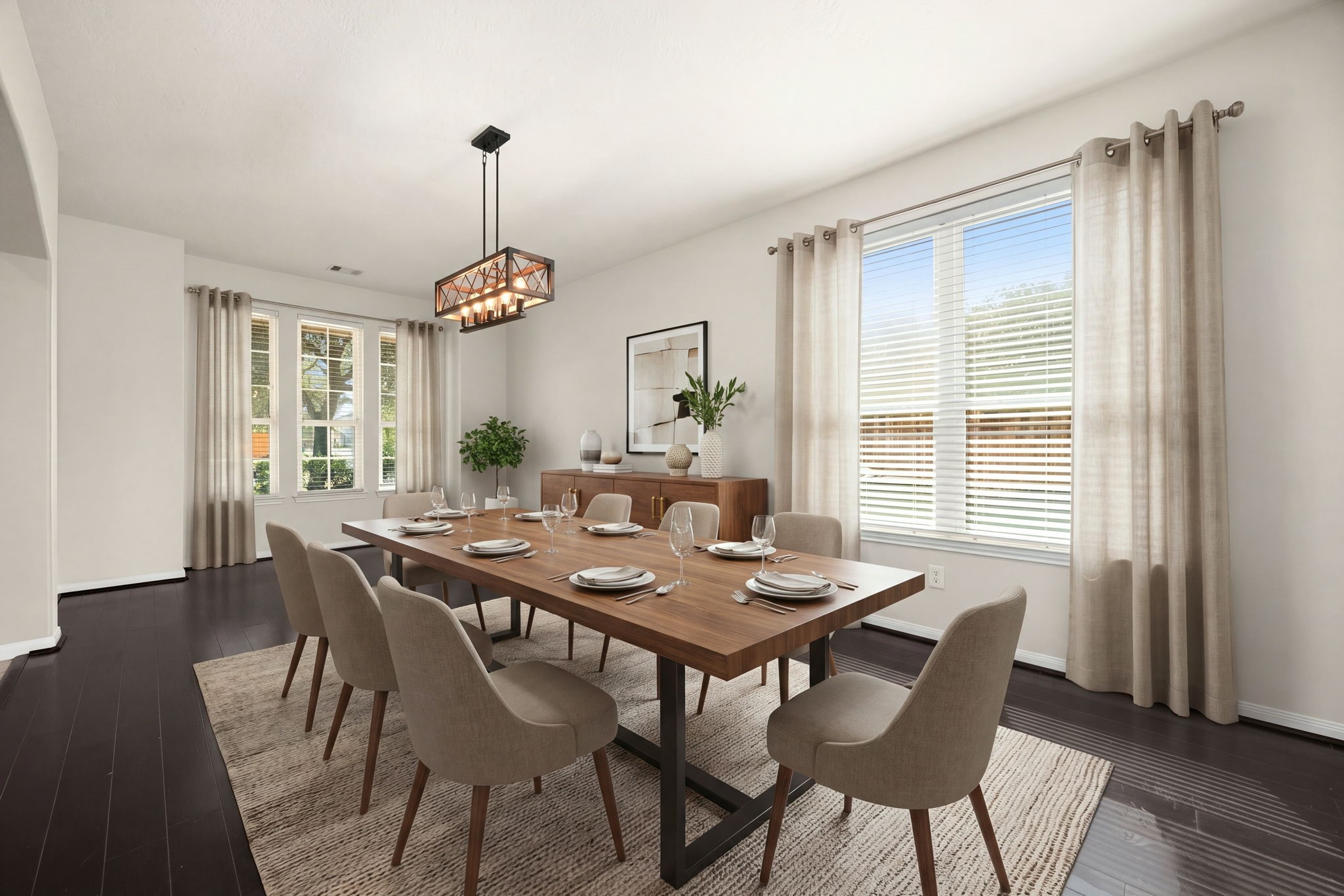 The elegant formal dining room is a sophisticated space designed for seamless entertaining and memorable gatherings. Anchored by gorgeous dark hardwood flooring, the room features an abundance of natural light streaming through multiple large windows and is centered around a striking modern industrial statement chandelier. *Virtually Staged