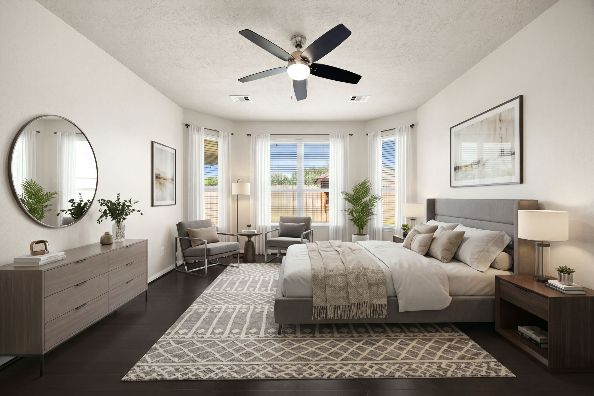 A beautiful bay window wall serves as the architectural focal point of this expansive primary bedroom, flooding the retreat with rich natural light. The sprawling layout features deep-toned wood flooring that contrasts elegantly with the neutral walls, high ceilings, a modern five-blade ceiling fan, and a dedicated sitting area perfect for relaxation. *Virtually Staged
