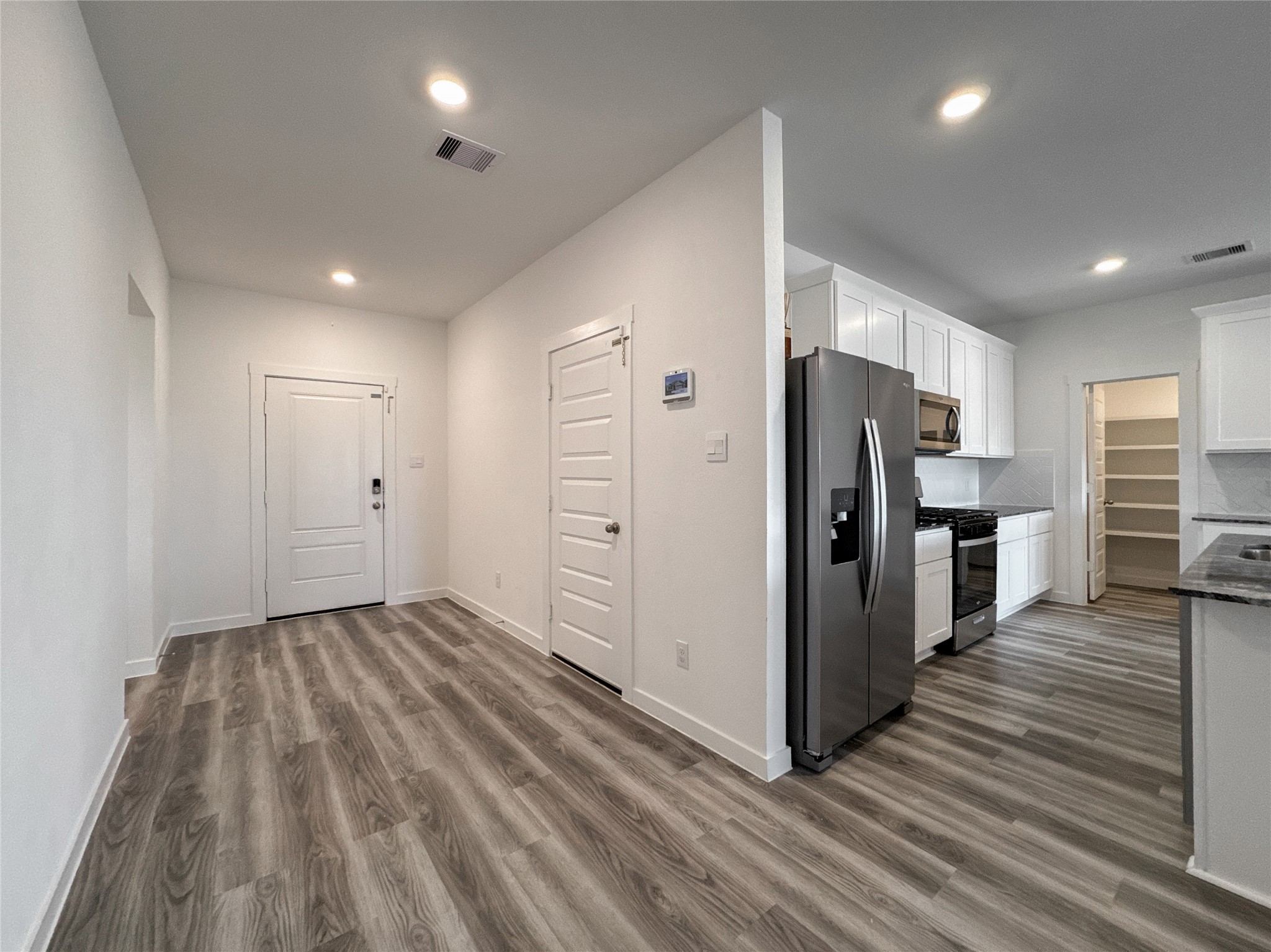 Front door inside view, garage exit connected to Living Room and Kitchen