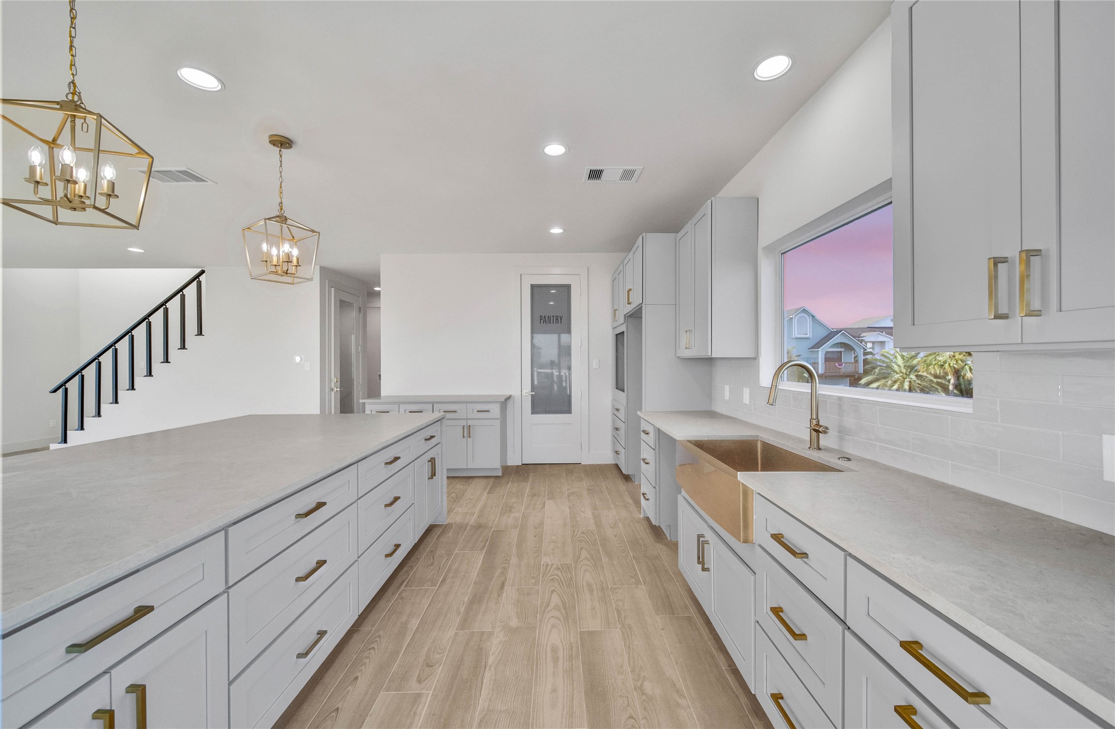 Another view of the kitchen showcasing its open design, extensive cabinetry, and seamless flow into the living area.