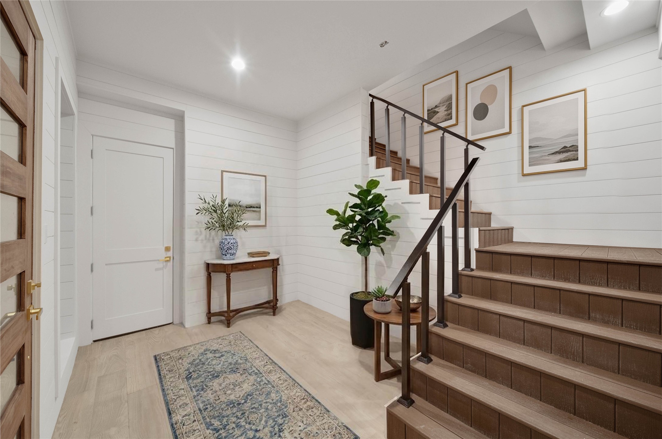 Warm and welcoming entryway with light floors and shiplap walls that enhance the bright, relaxed coastal feel. *virtually staged*