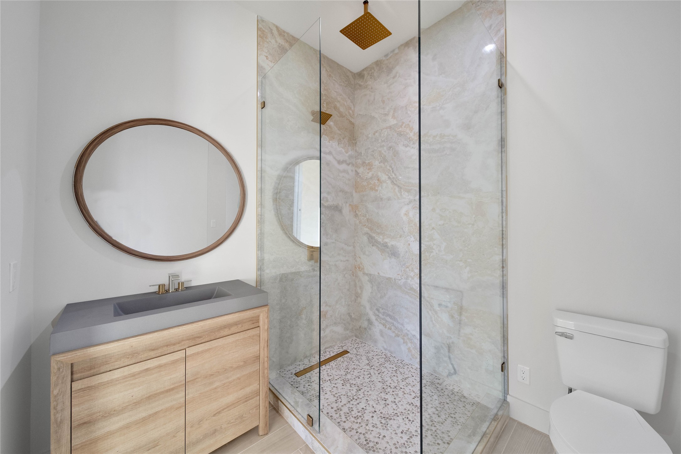 Stylish secondary bath with a glass-enclosed shower and contemporary finishes.