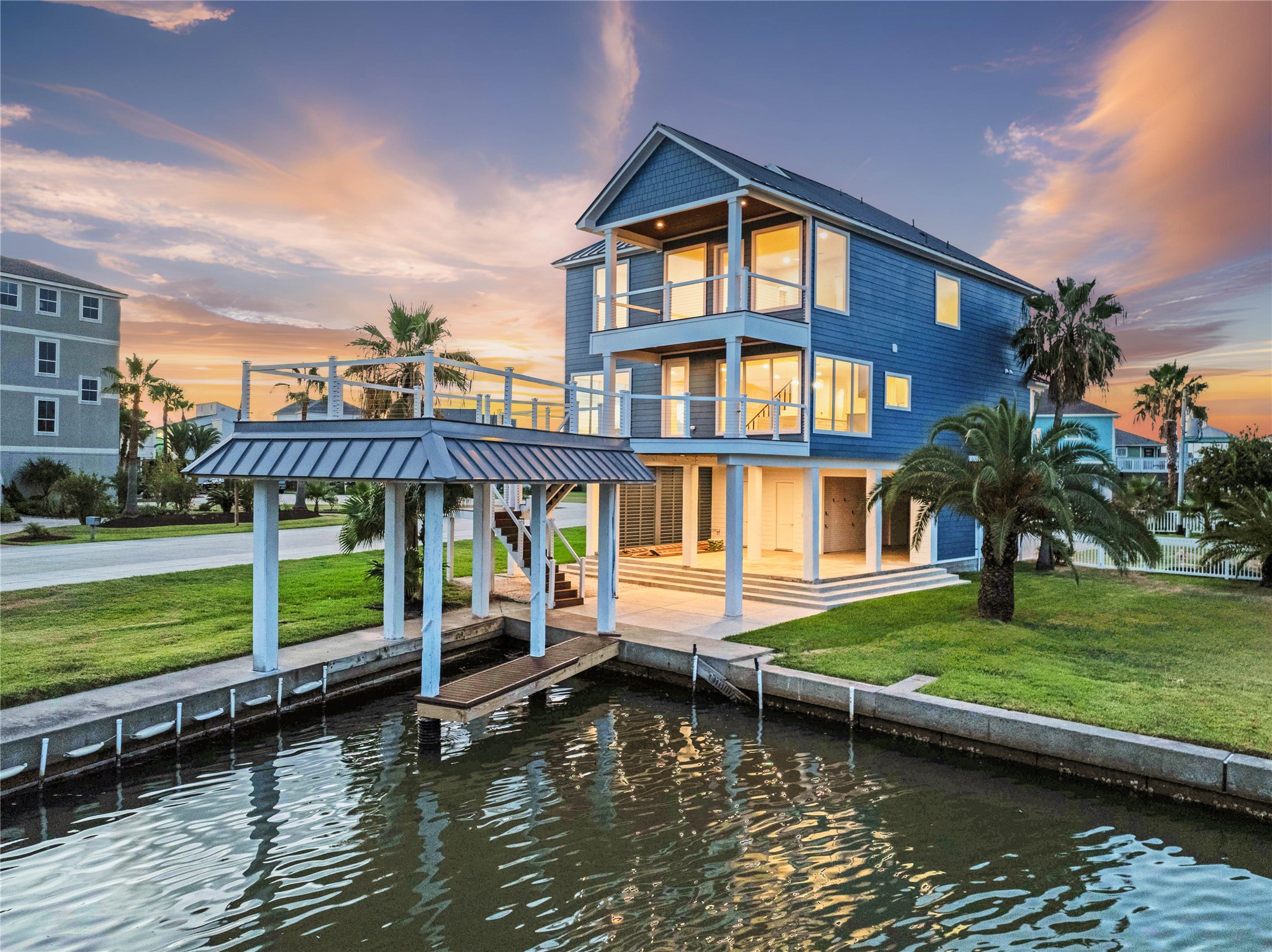 Beautiful waterfront living on Tiki Island. Private canal access, boat dock, sunset views showcasing multiple levels of outdoor living and picturesque coastal views.