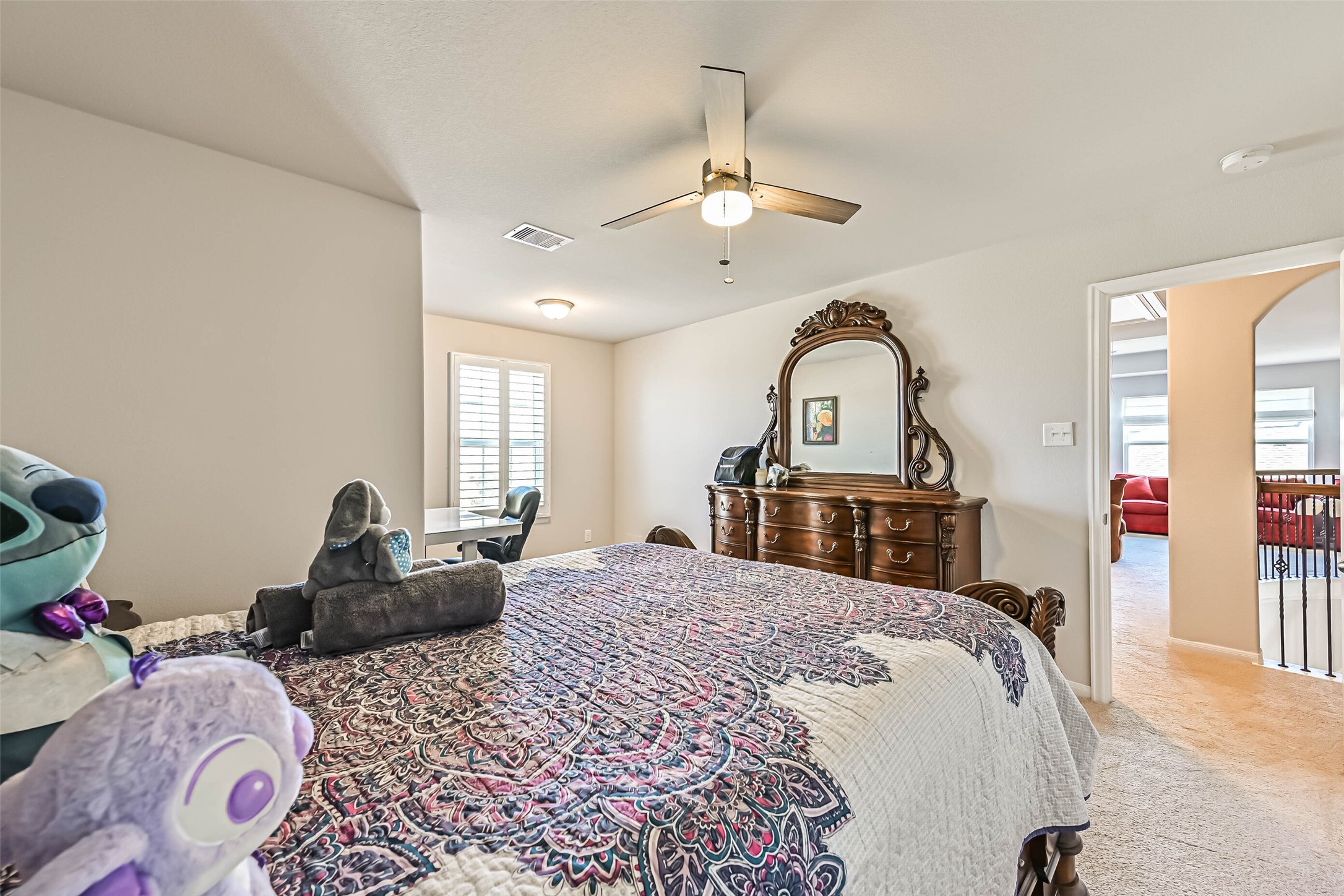 Additional view highlighting the bedroom's spacious layout, natural light, and versatile furniture arrangement.