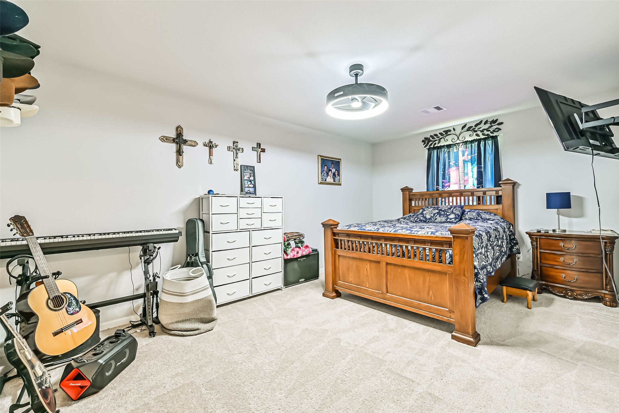 Another view of the spacious secondary bedroom featuring a modern ceiling fan, neutral finishes, and plenty of room for additional furniture or a workspace.