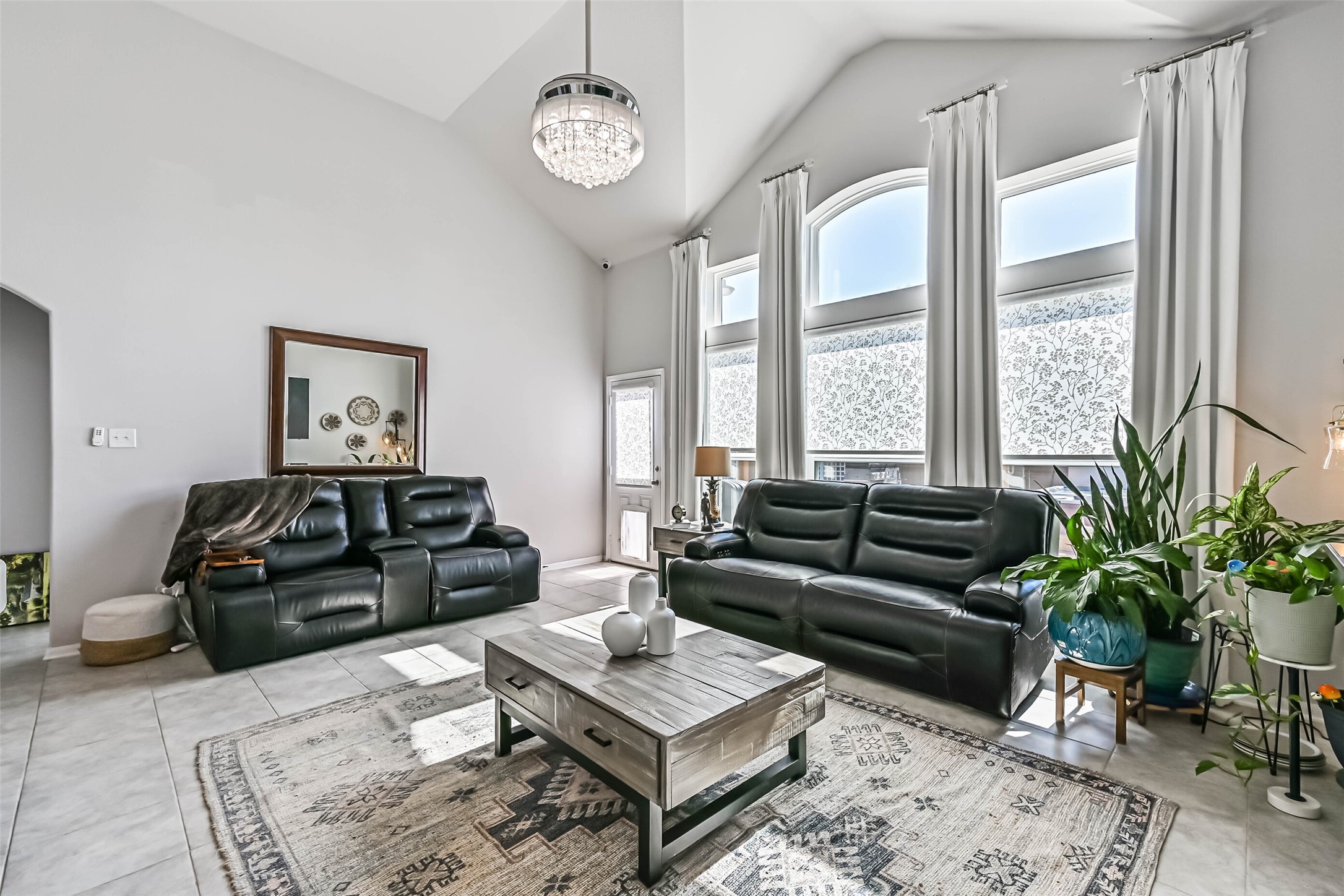 Beautiful living area with vaulted ceilings, oversized windows, abundant natural light, and plenty of room for comfortable seating.