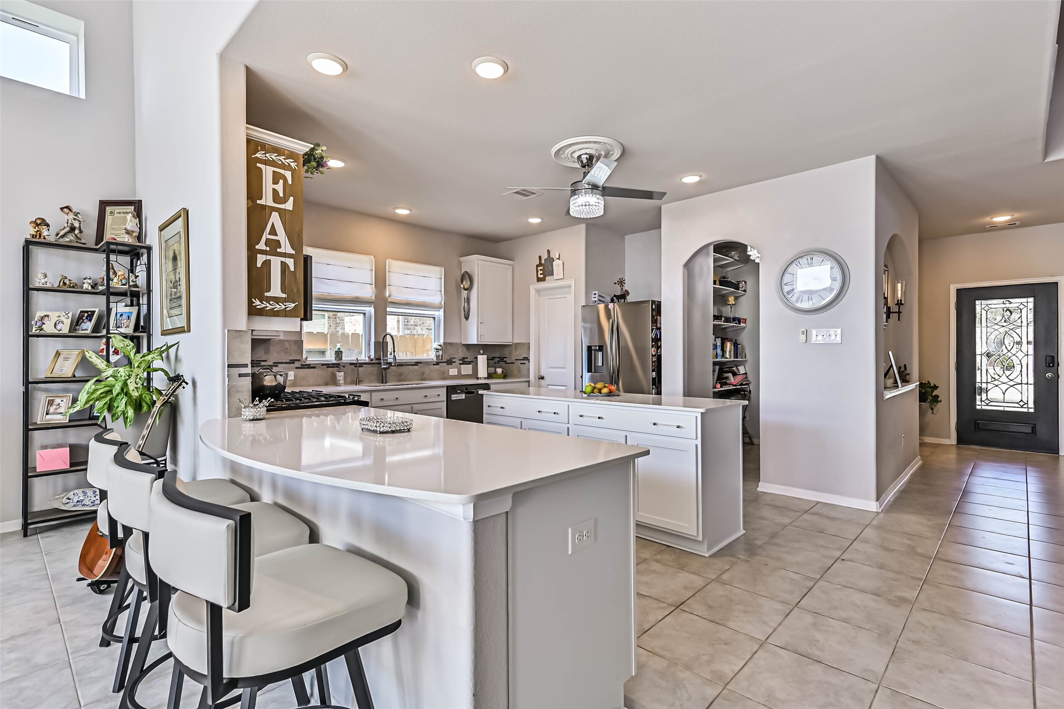 Beautiful open-concept kitchen overlooking the spacious living area, featuring white cabinetry, generous counter space, and abundant natural light.