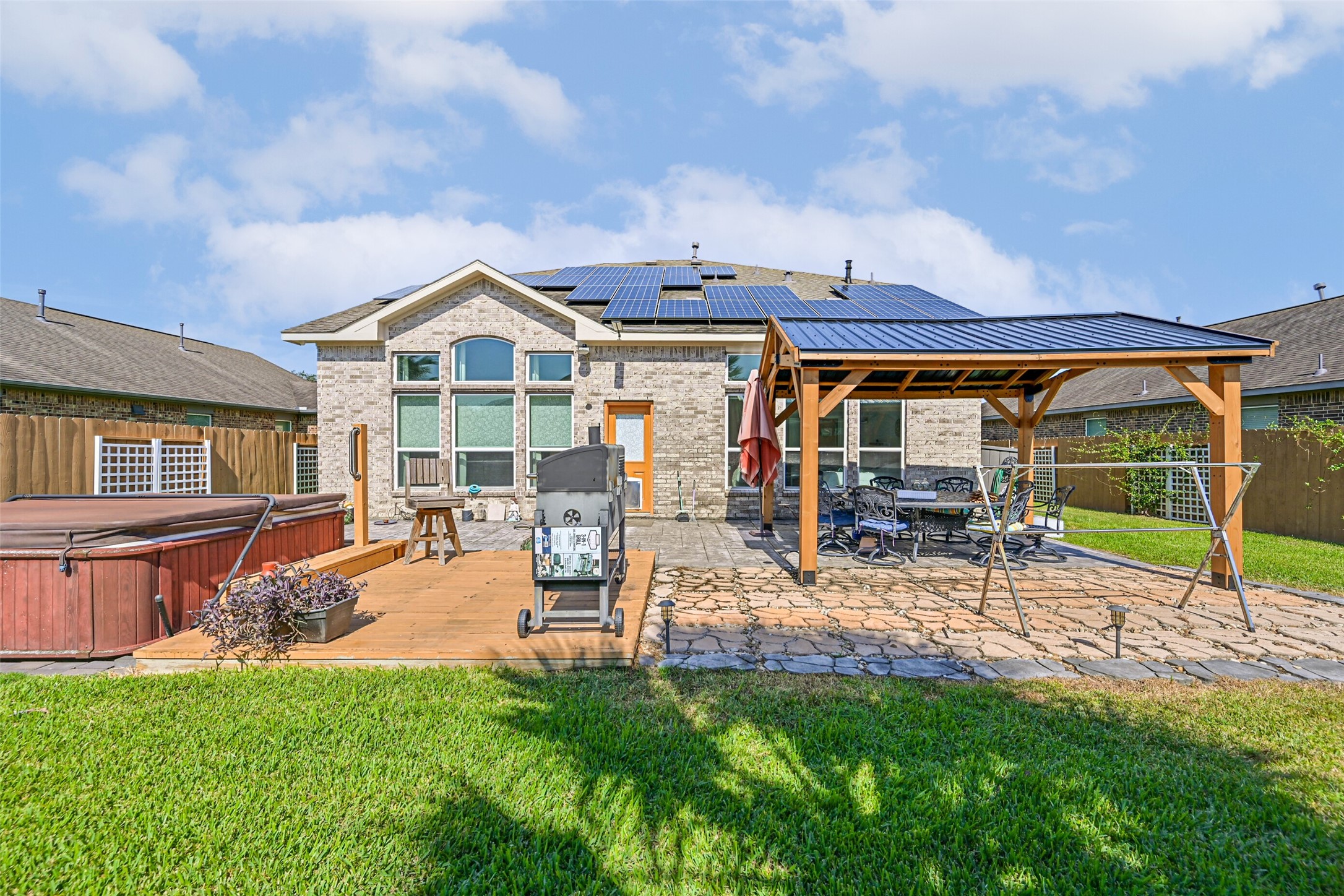 Enjoy outdoor living with a spacious patio, custom-built covered seating area, and plenty of room for grilling and entertaining.
