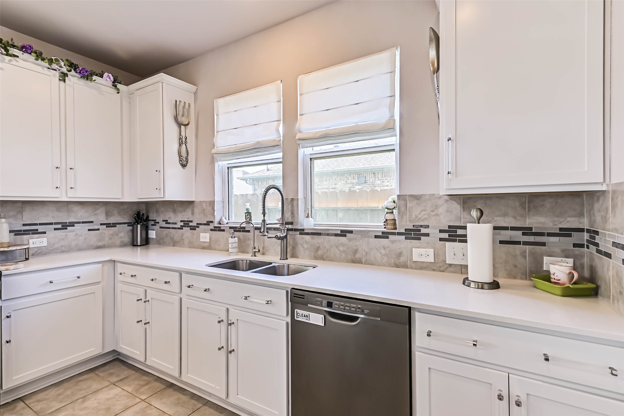 Kitchen features a double-basin sink, modern pull-down faucet, stainless steel dishwasher, and plenty of counter space.