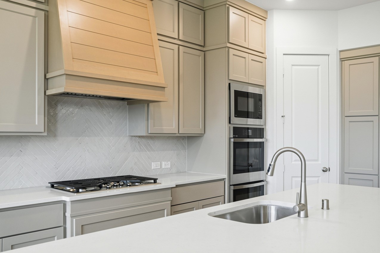 Designer kitchen with premium finishes, extensive cabinetry, and modern built-in appliances.