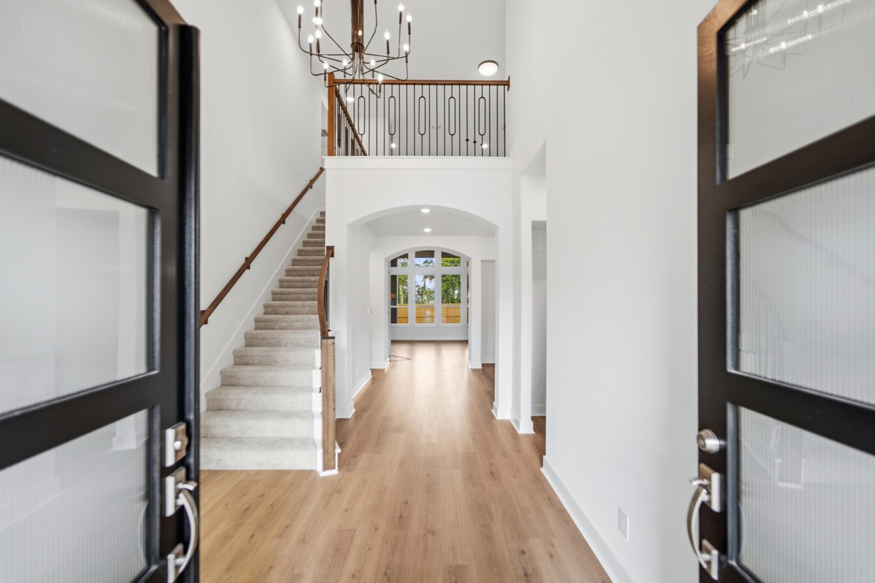 Grand foyer featuring soaring ceilings, an elegant staircase, and an impressive first impression.