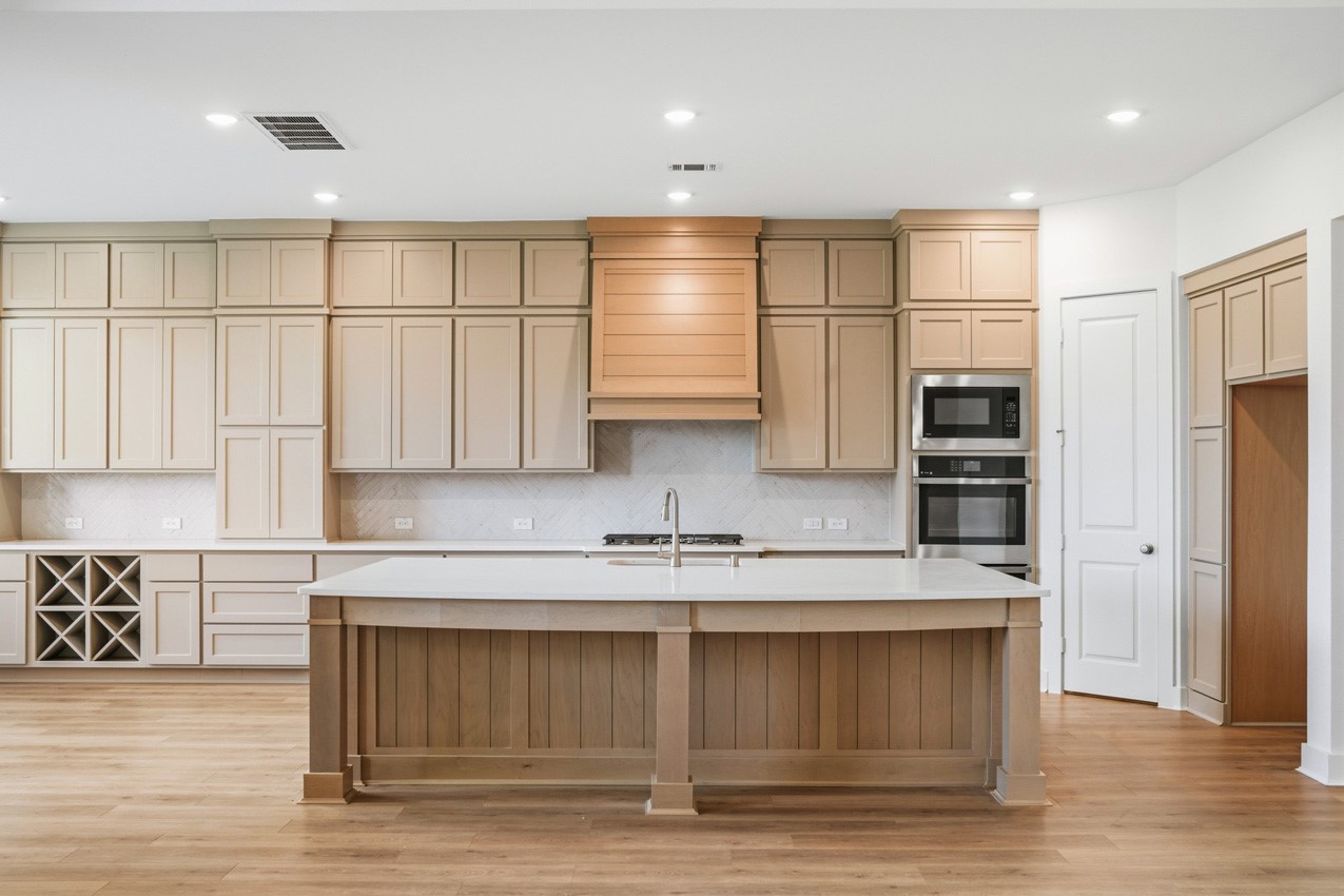 Bright gourmet kitchen with abundant cabinetry, a spacious island, and an open layout.